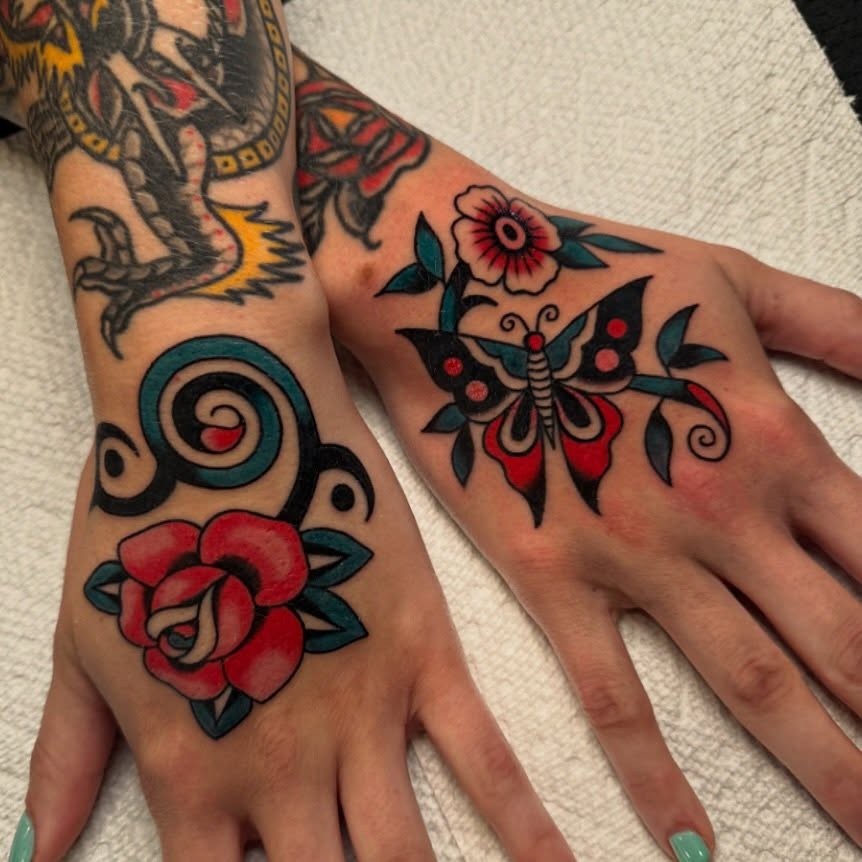 Butterfly and floral American traditional tattoo on the hand by kate