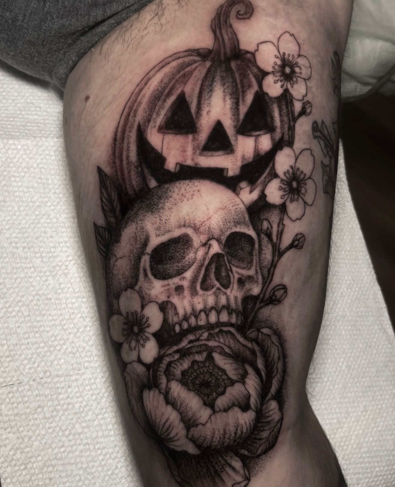 Skull and pumpkin dotwork tattoo on the thigh by Sal
