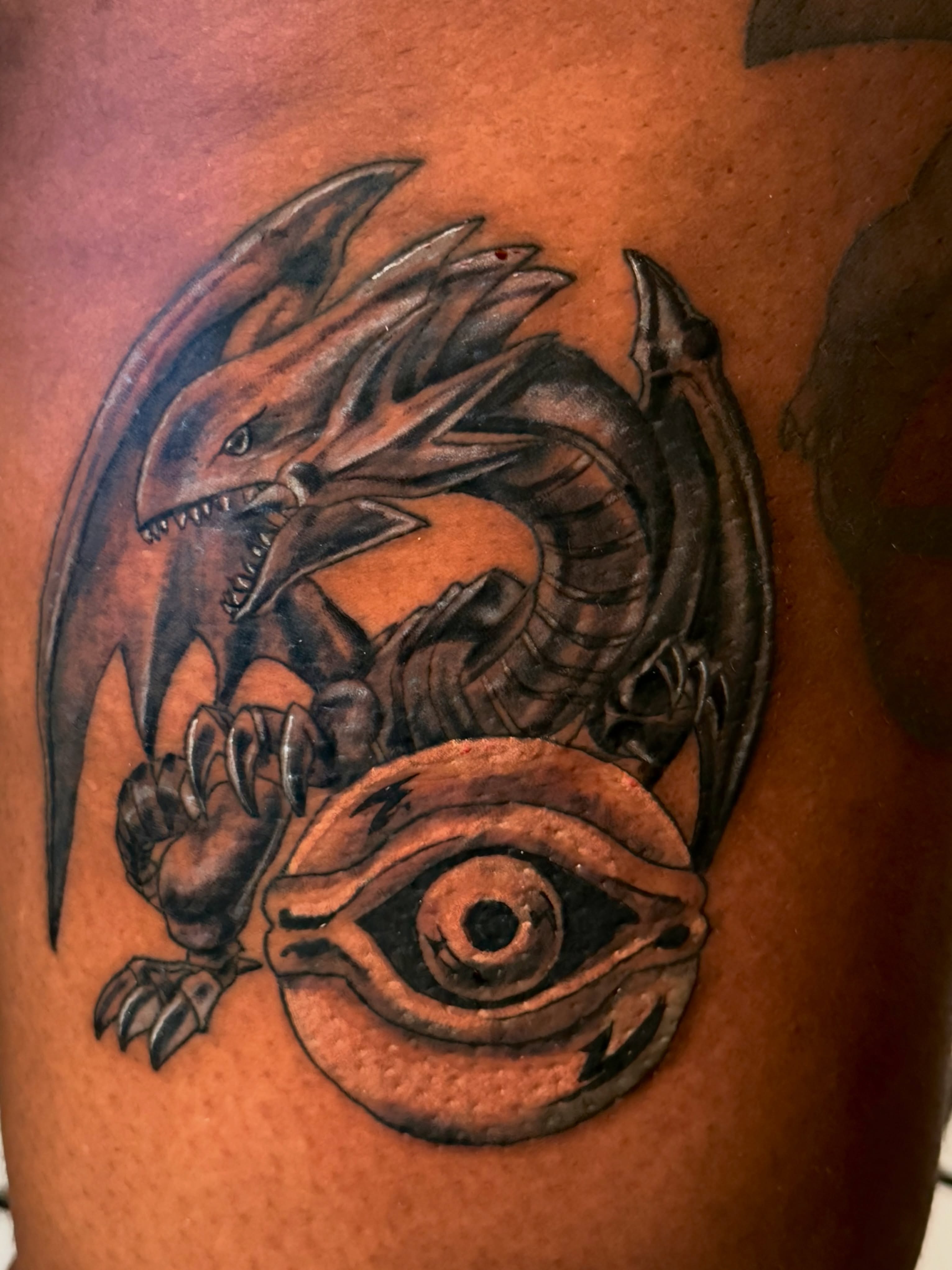 Dragon and eye realism tattoo on the thigh by Alexander Haber