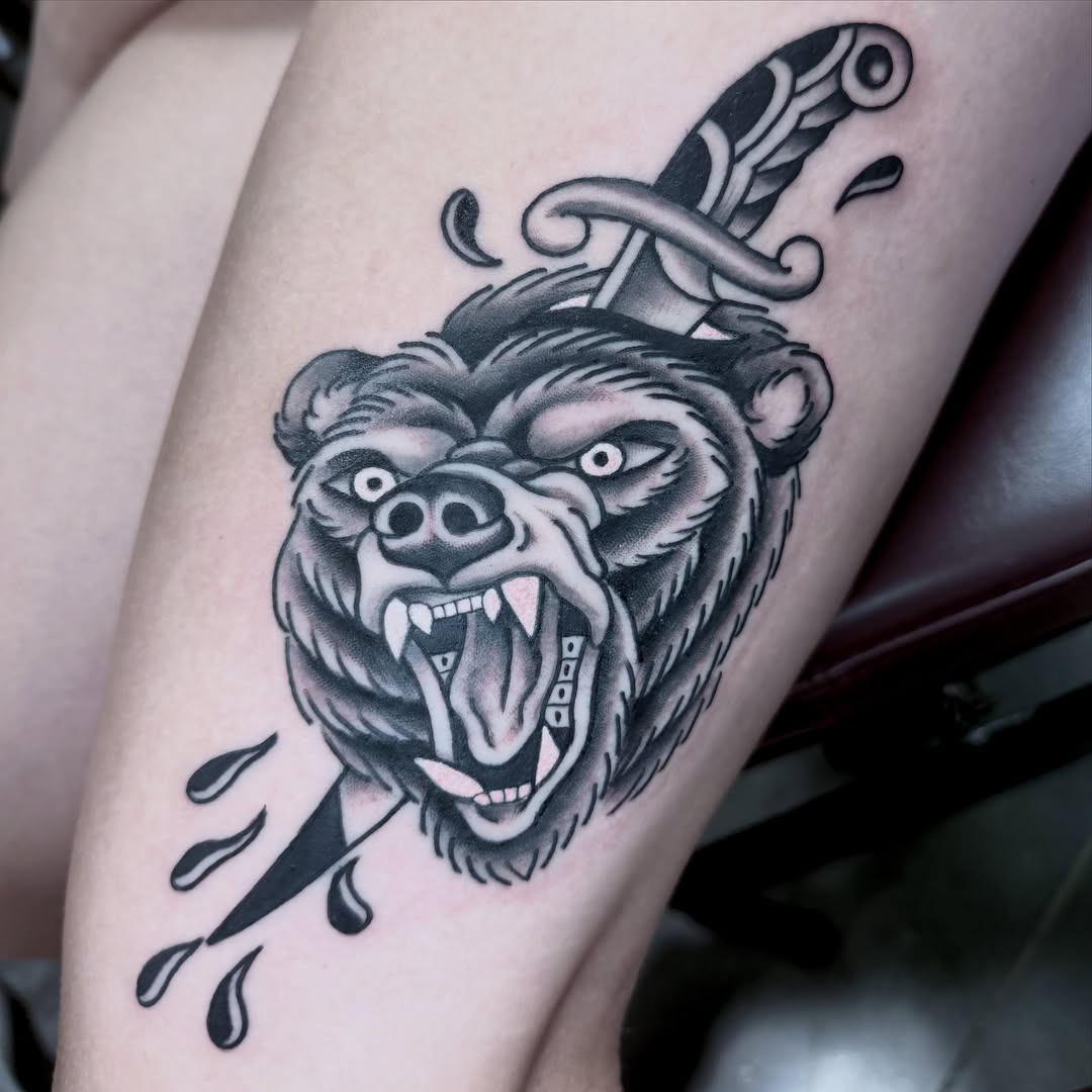 Bear head with dagger American traditional tattoo on the thigh by Holli Marie
