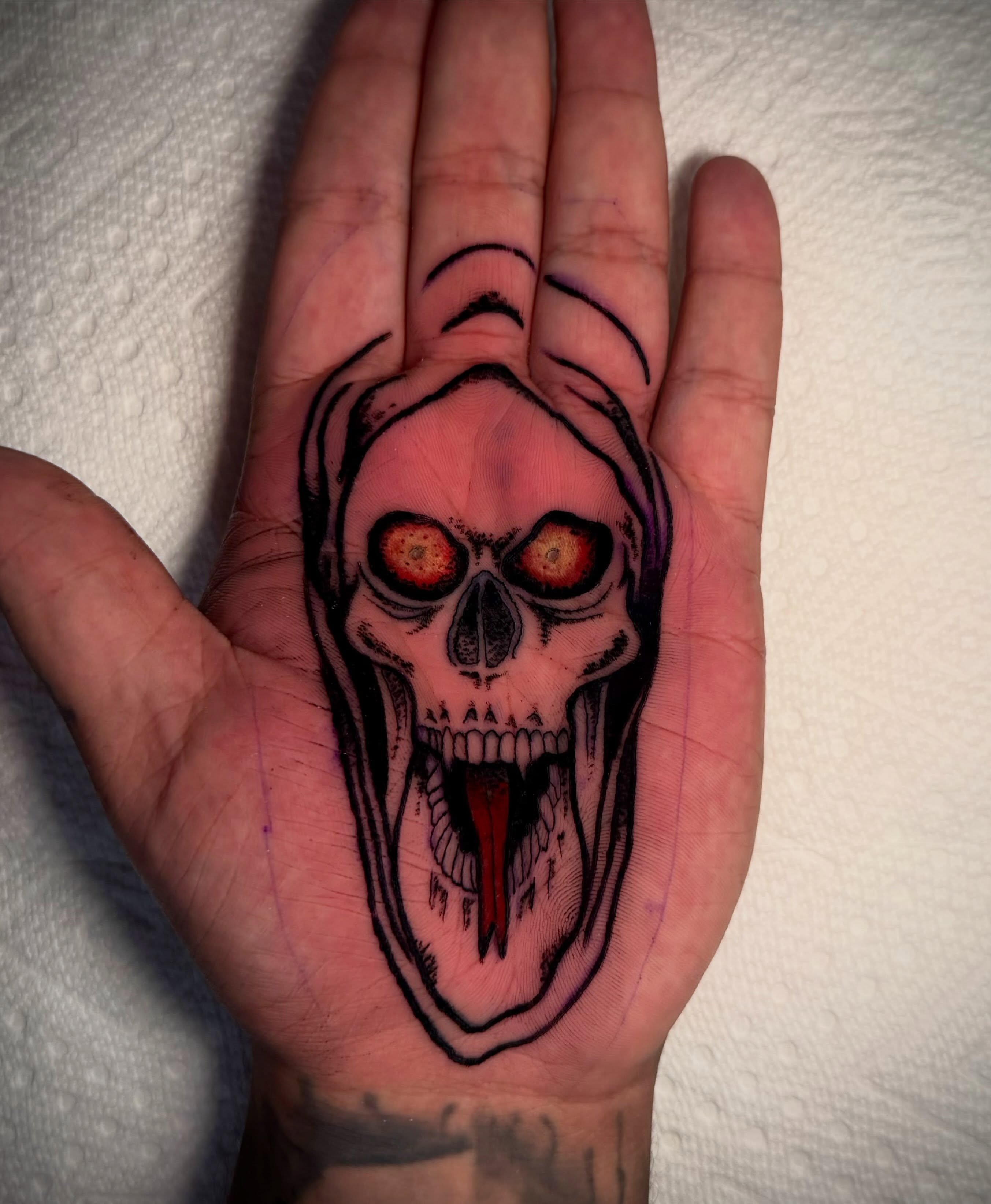 Screaming skull dark realism tattoo on the hand by Lydia