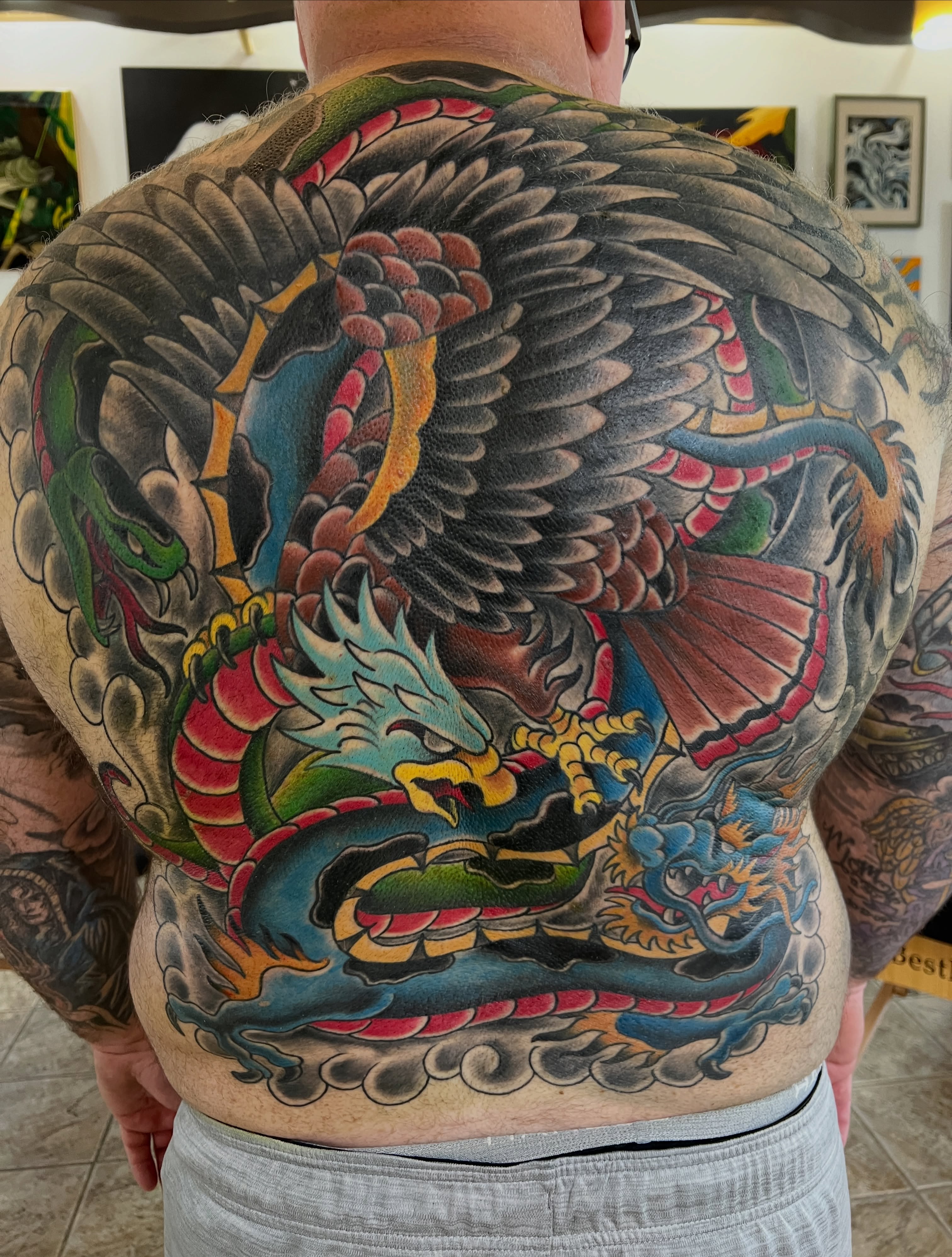 Dragon and phoenix American traditional tattoo on the back by Cary Aldridge