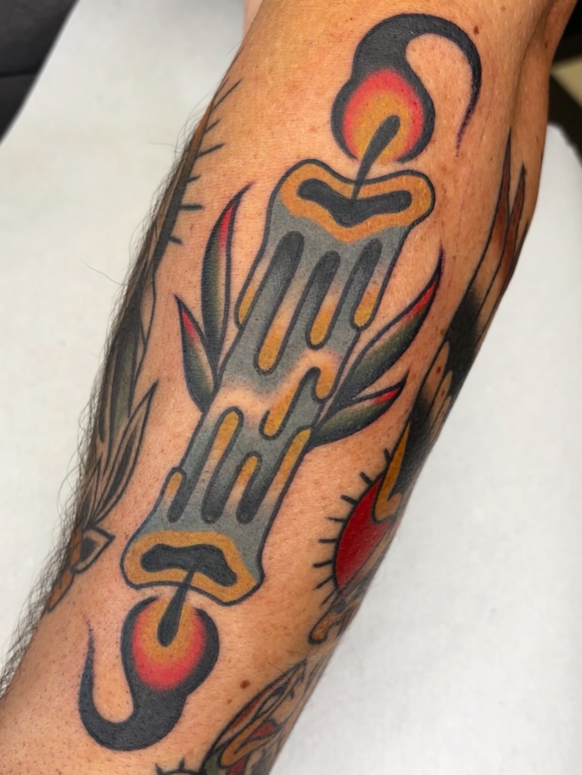 Fork and candle American traditional tattoo on the forearm by Arturo Ledesma