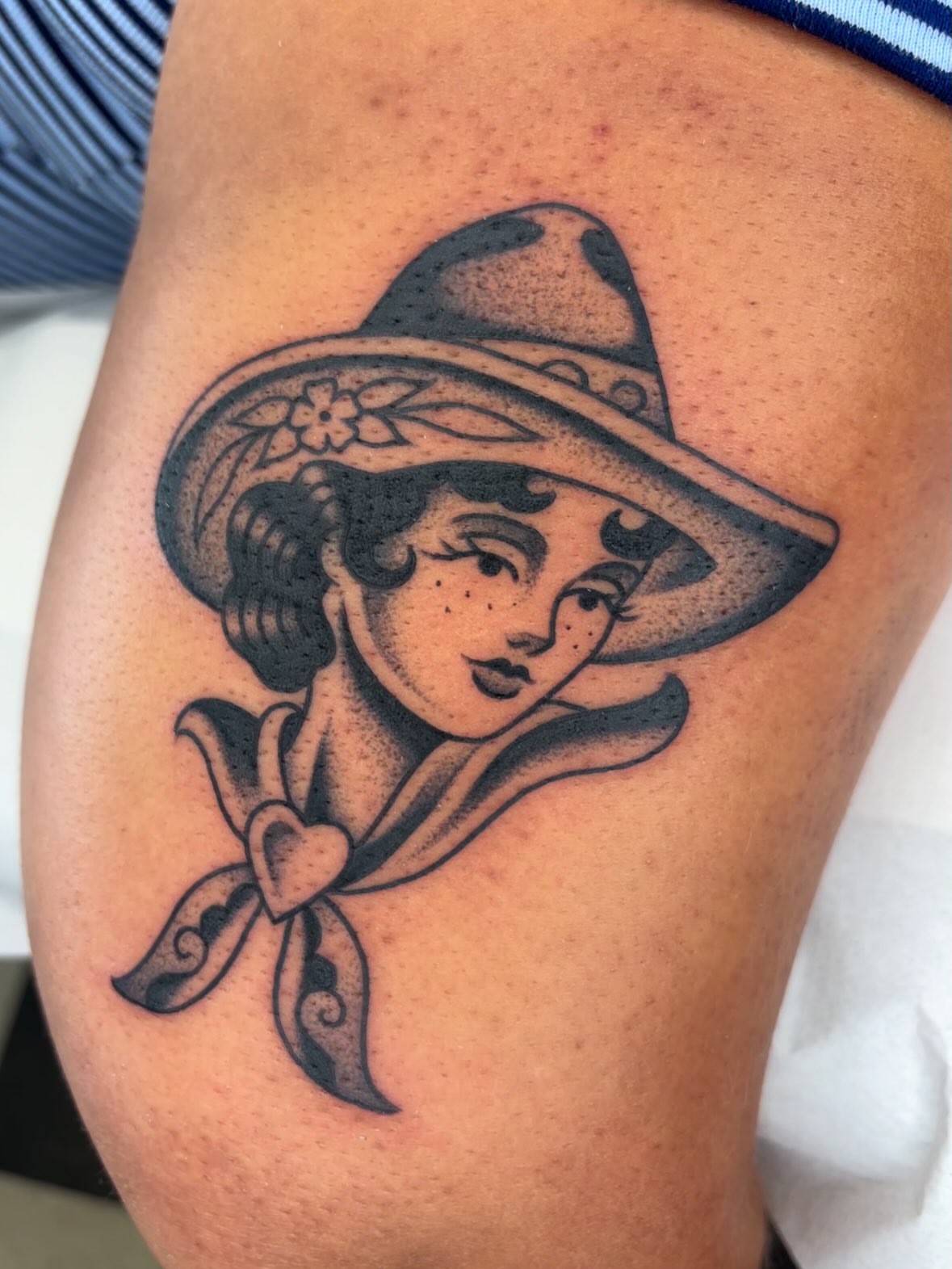 Woman wearing hat American traditional tattoo on the thigh by Arturo Ledesma