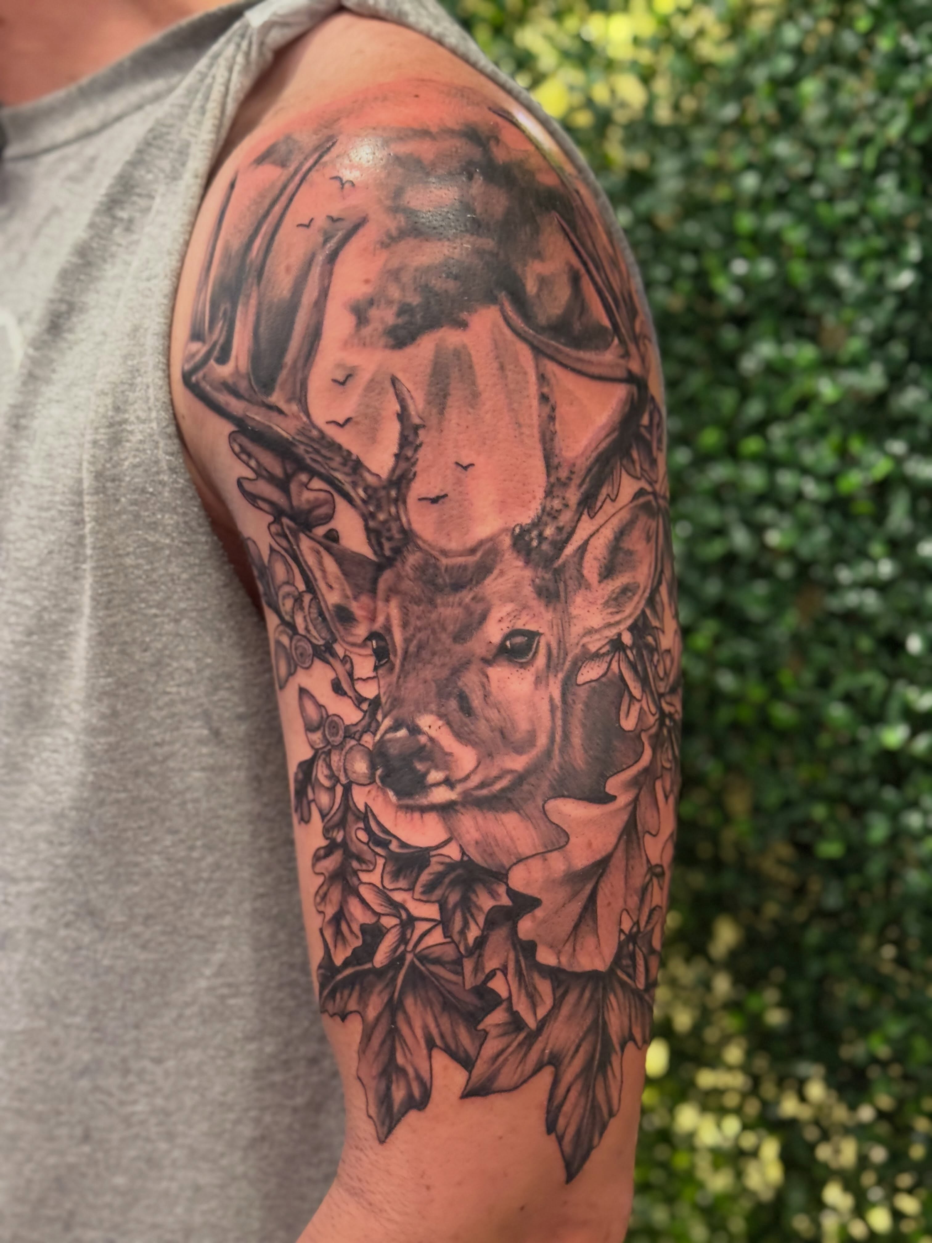 Deer and foliage realism tattoo on the forearm by Lauren Horness
