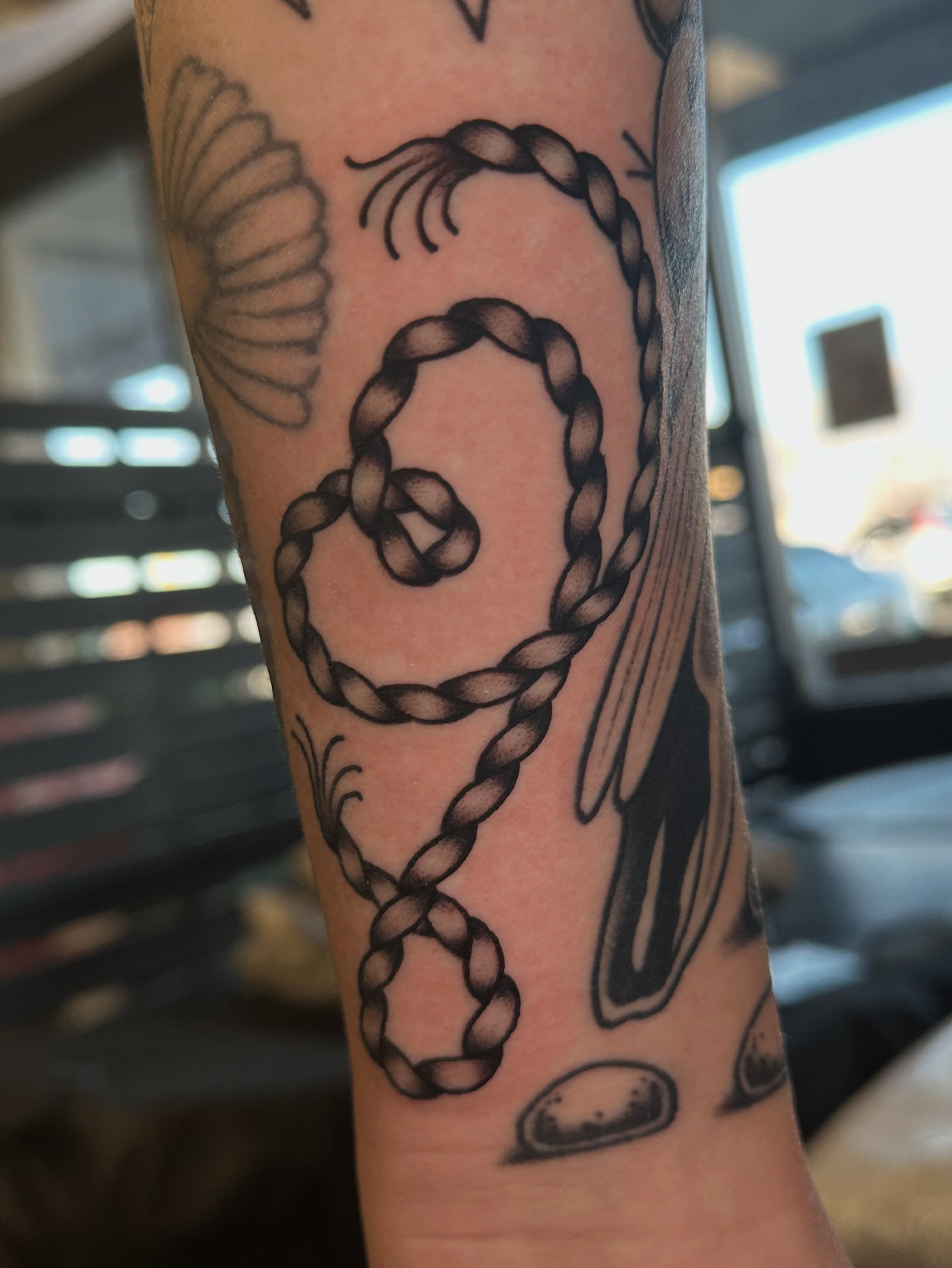 Braided rope black and grey tattoo on the forearm by Lauren Howard Tattoos