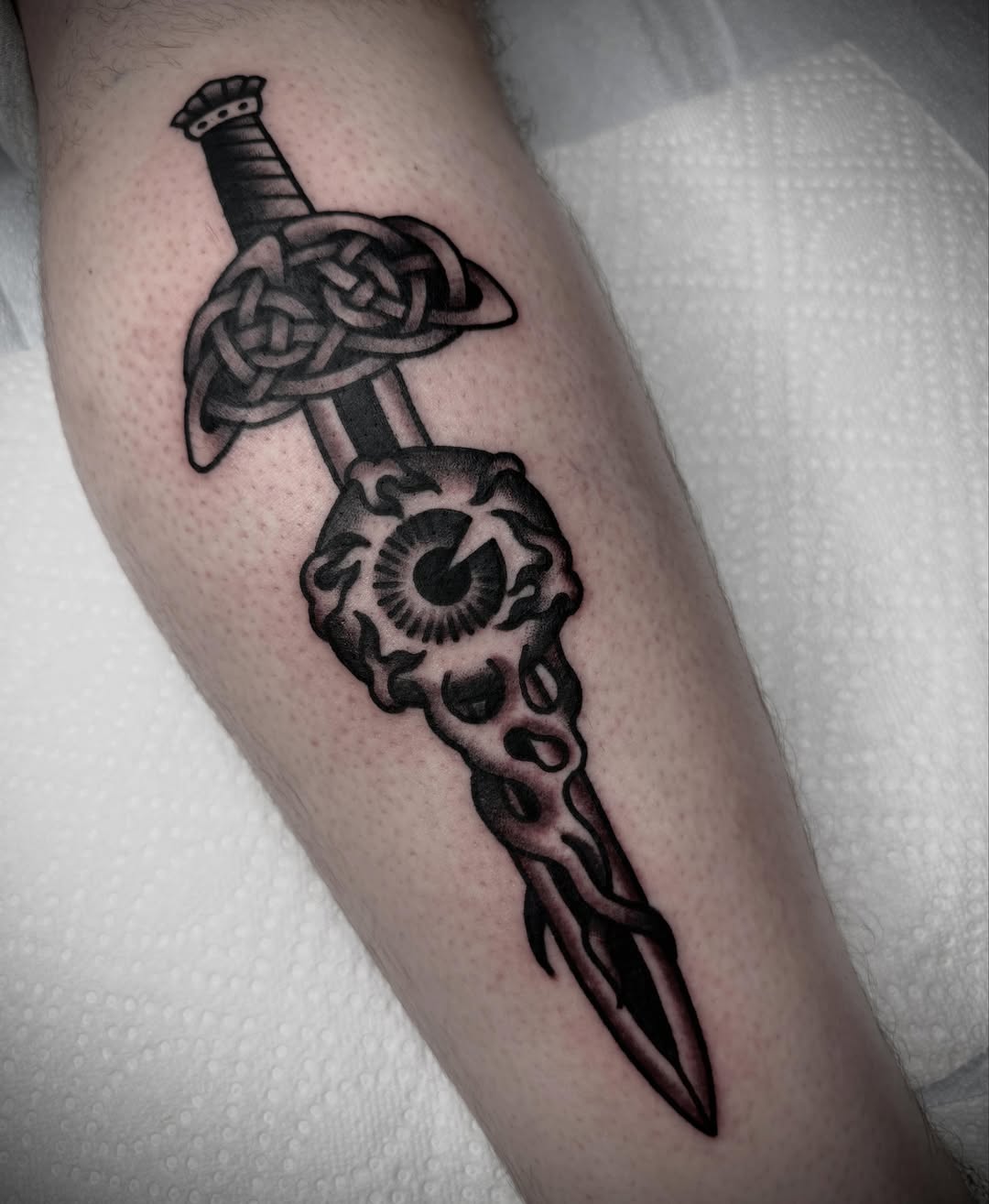 Sword and knot black and grey tattoo on the forearm by Tristan Bradshaw