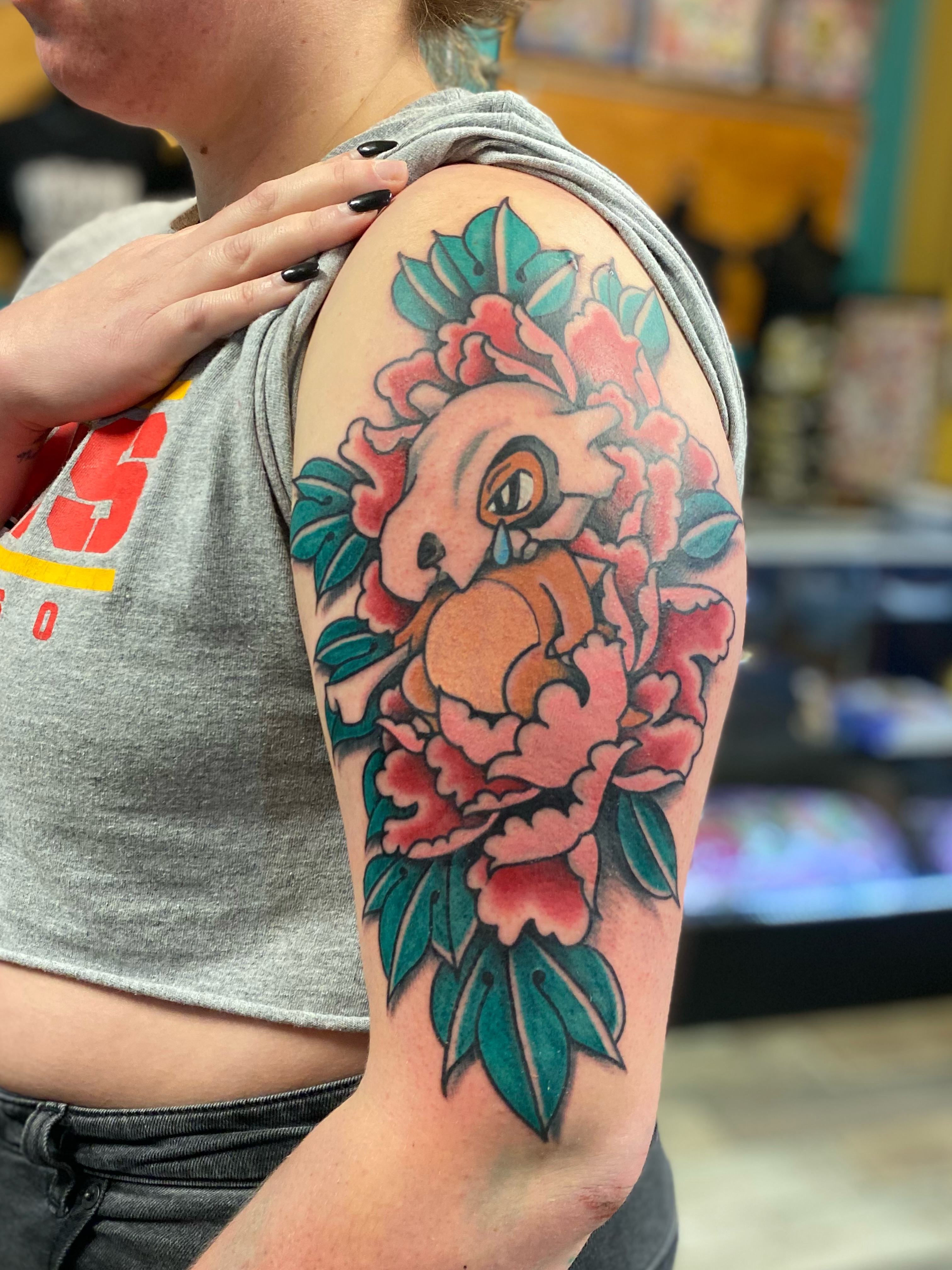 Peony and bird American traditional tattoo on the upper arm by Nick Weaver