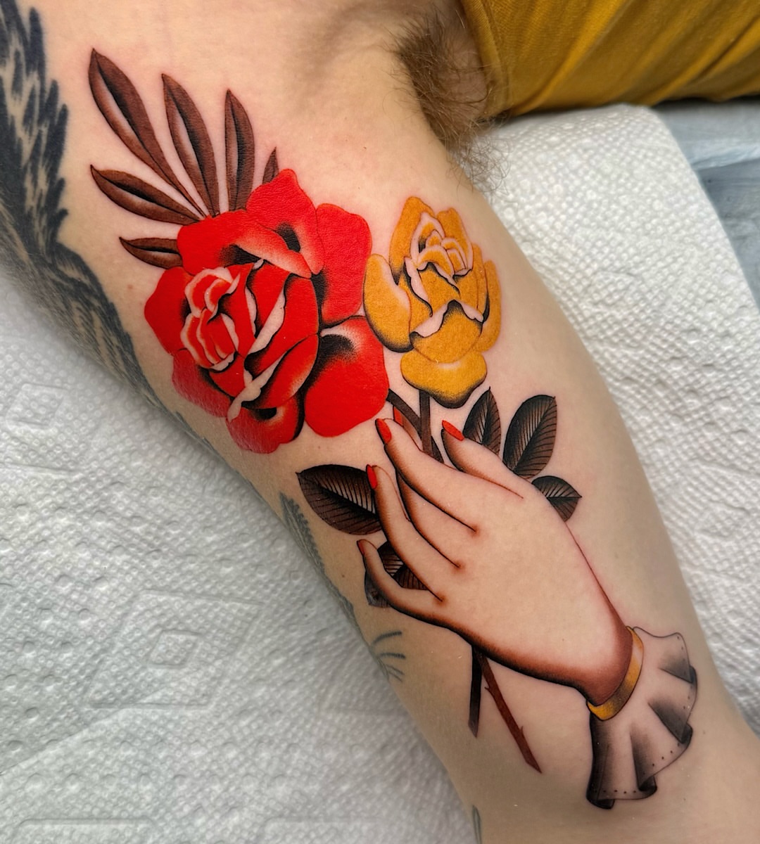 Flowers and hand American traditional tattoo on the forearm by Shelby Ouellette