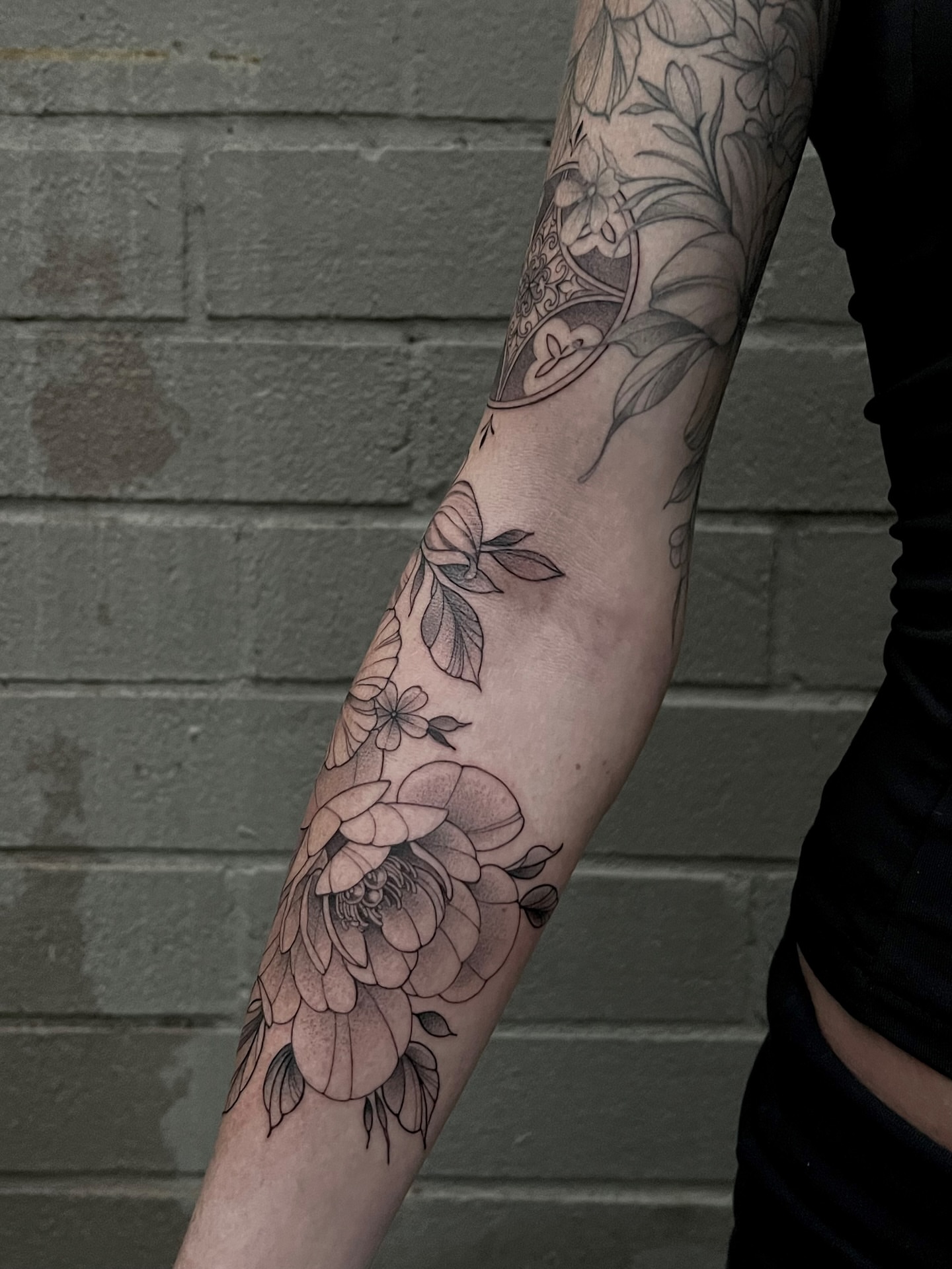 Floral arrangement black and grey tattoo on the forearm by Tehnaya