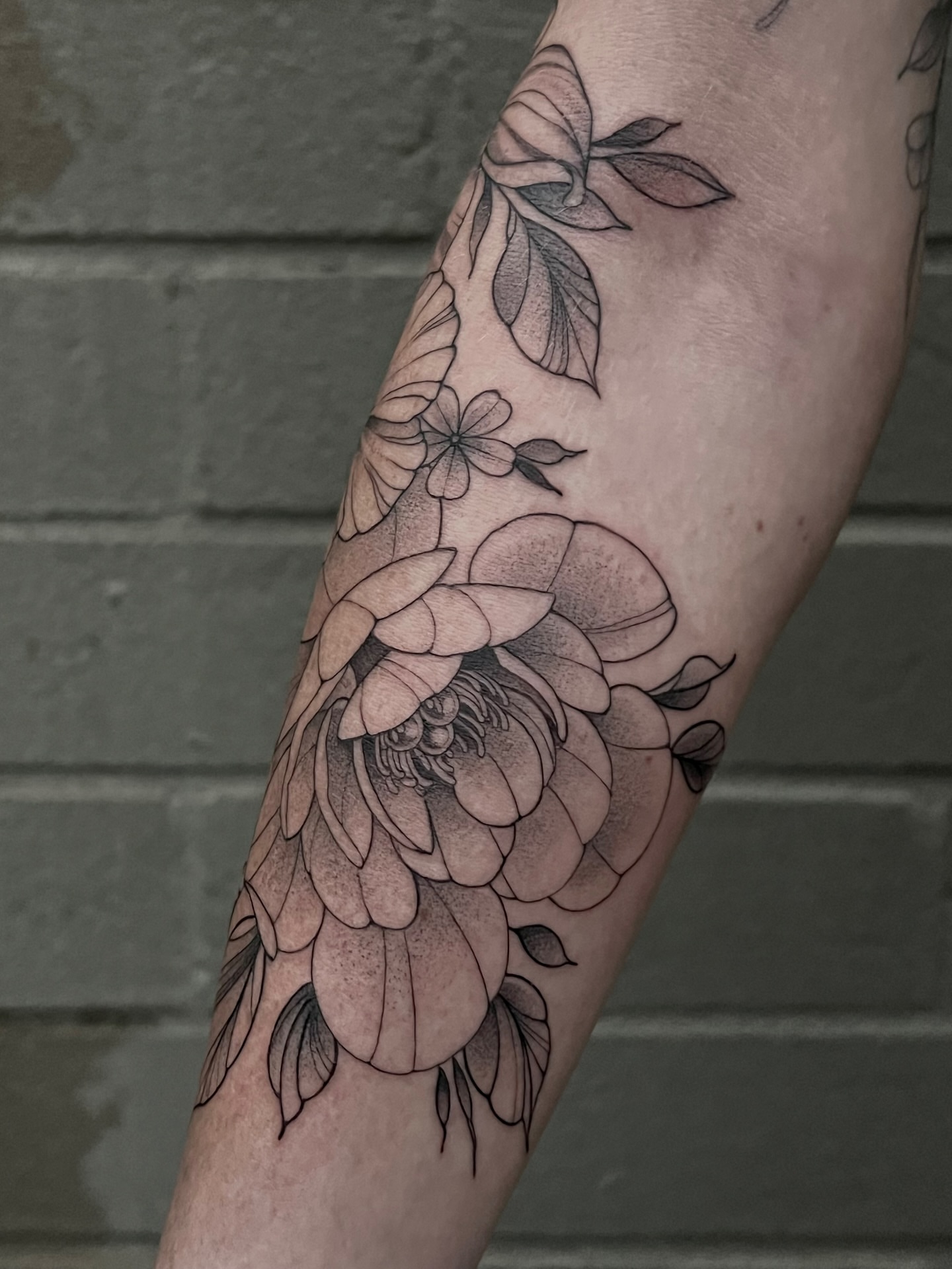 Floral arrangement black and grey tattoo on the forearm by Tehnaya