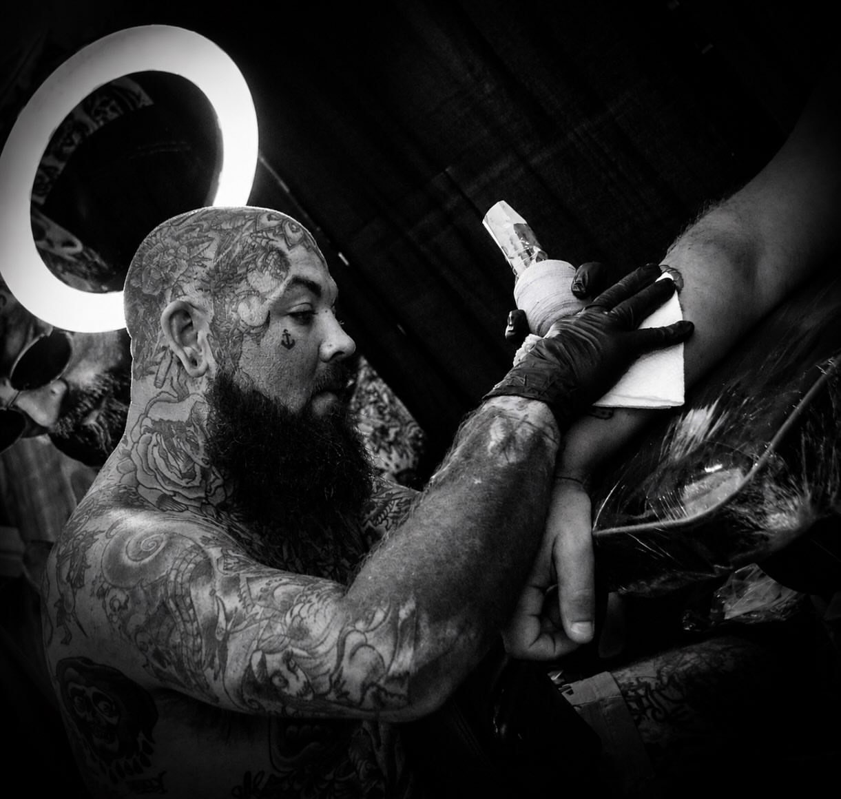 Bearded man with tattoos American traditional tattoo on the upper arm by Andres Flores