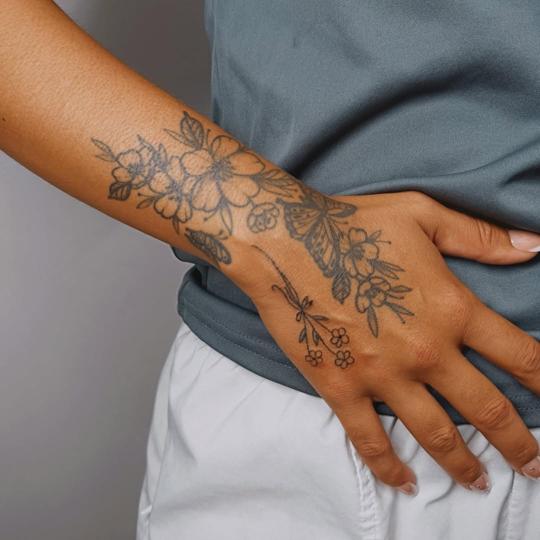 Floral and butterfly black and grey tattoo on the forearm by Ashlee Burkey