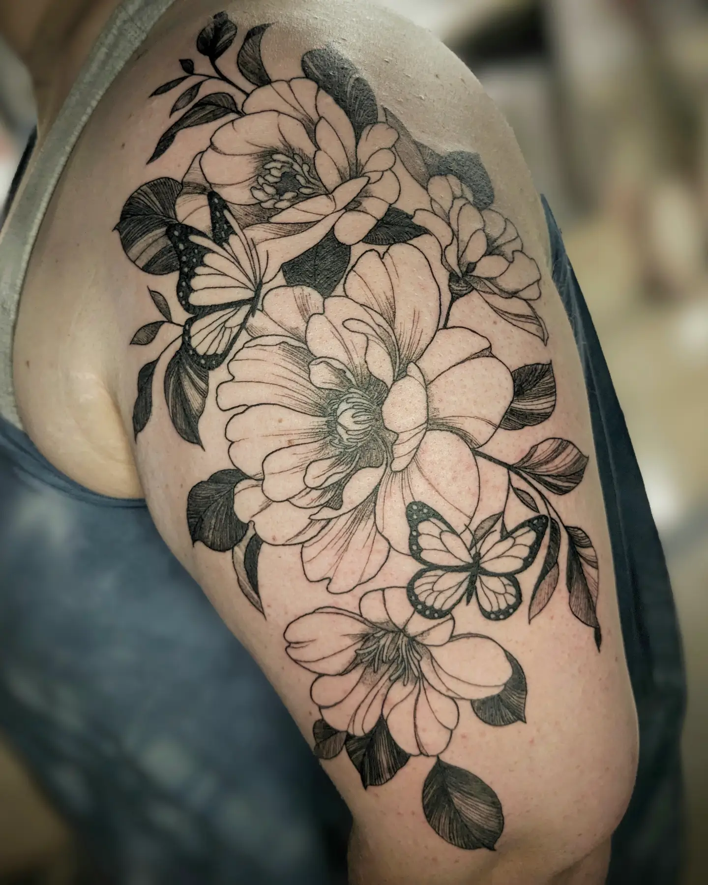 Flowers and butterflies black and grey tattoo on the shoulder by Seth Chitwood