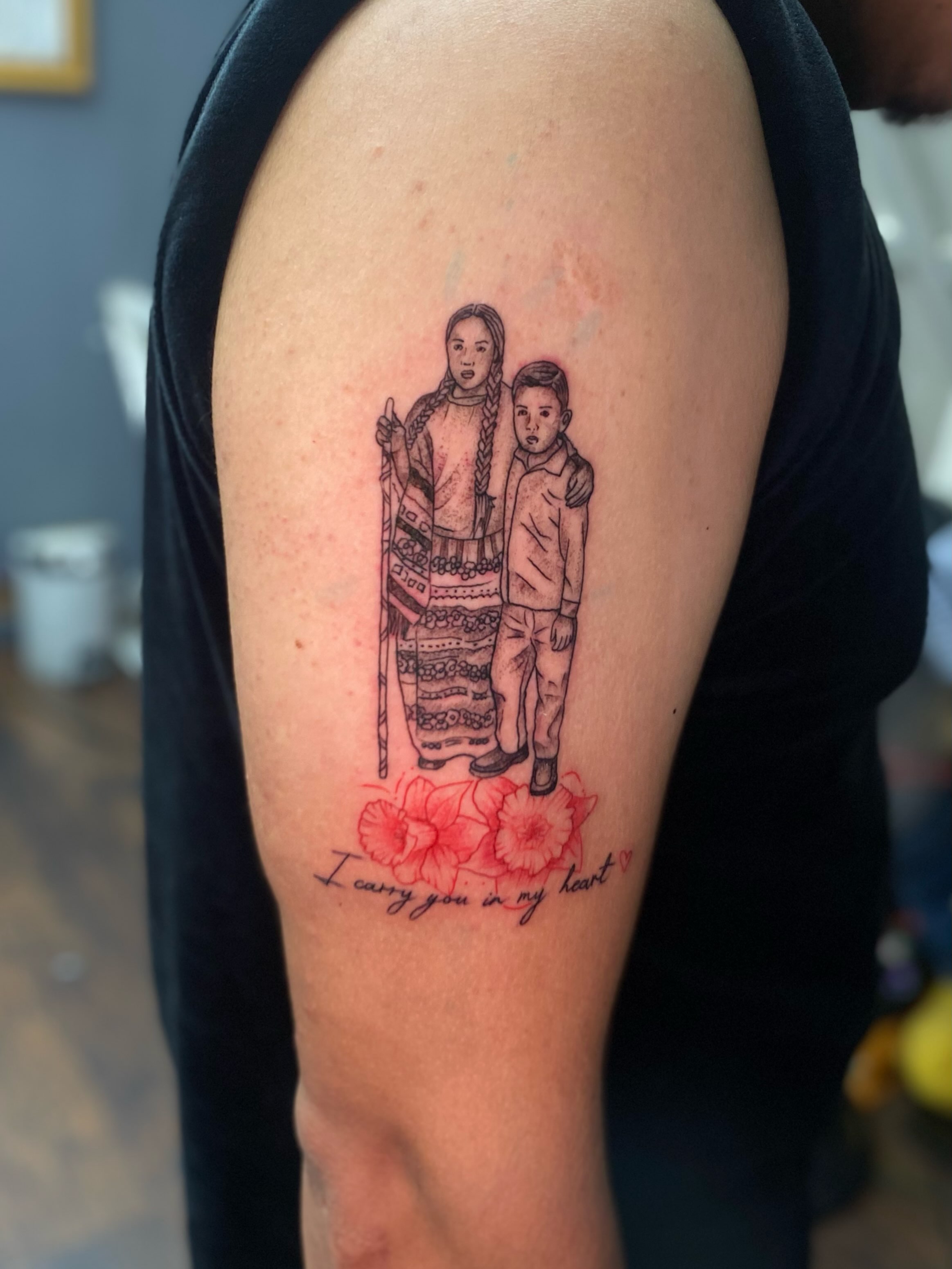 Portrait of two figures realism tattoo on the upper arm by Irving Guzman