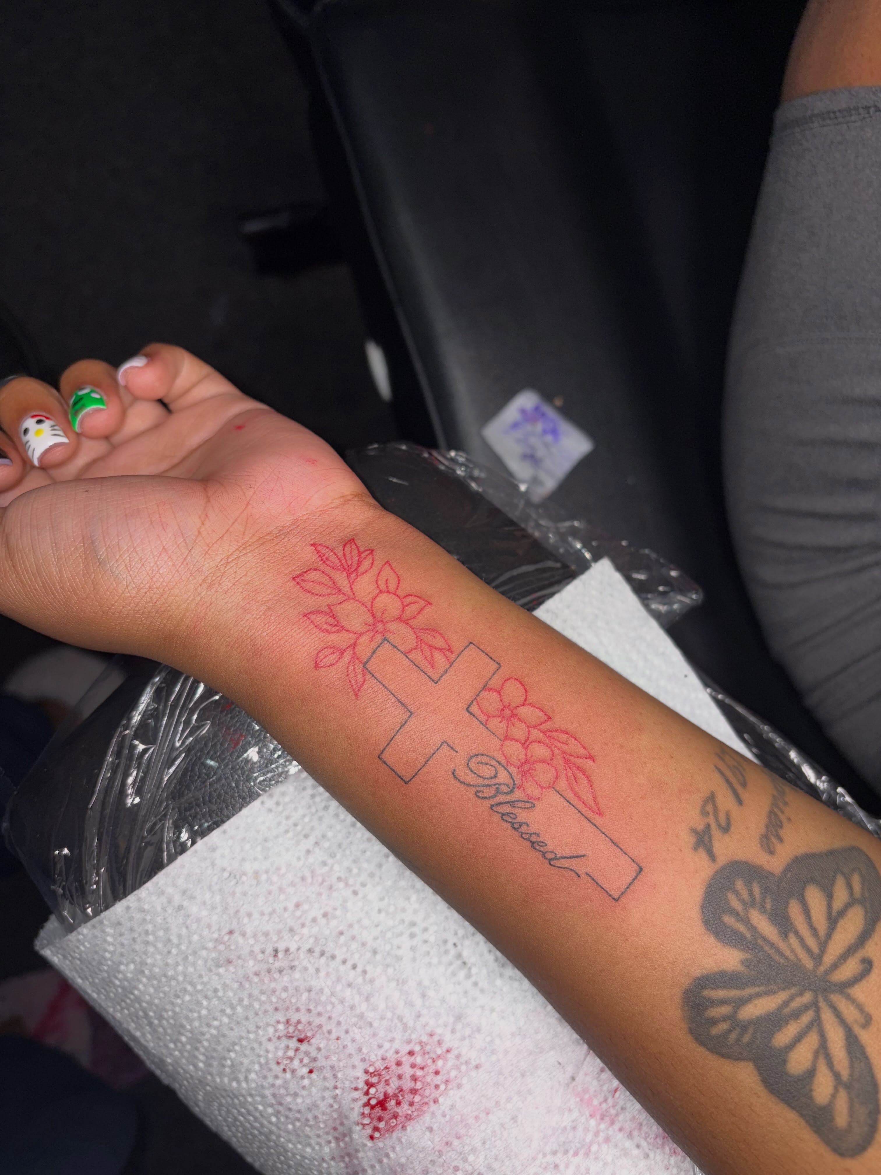 Cross with flowers fine line tattoo on the forearm by 216 Tattoos 🥰