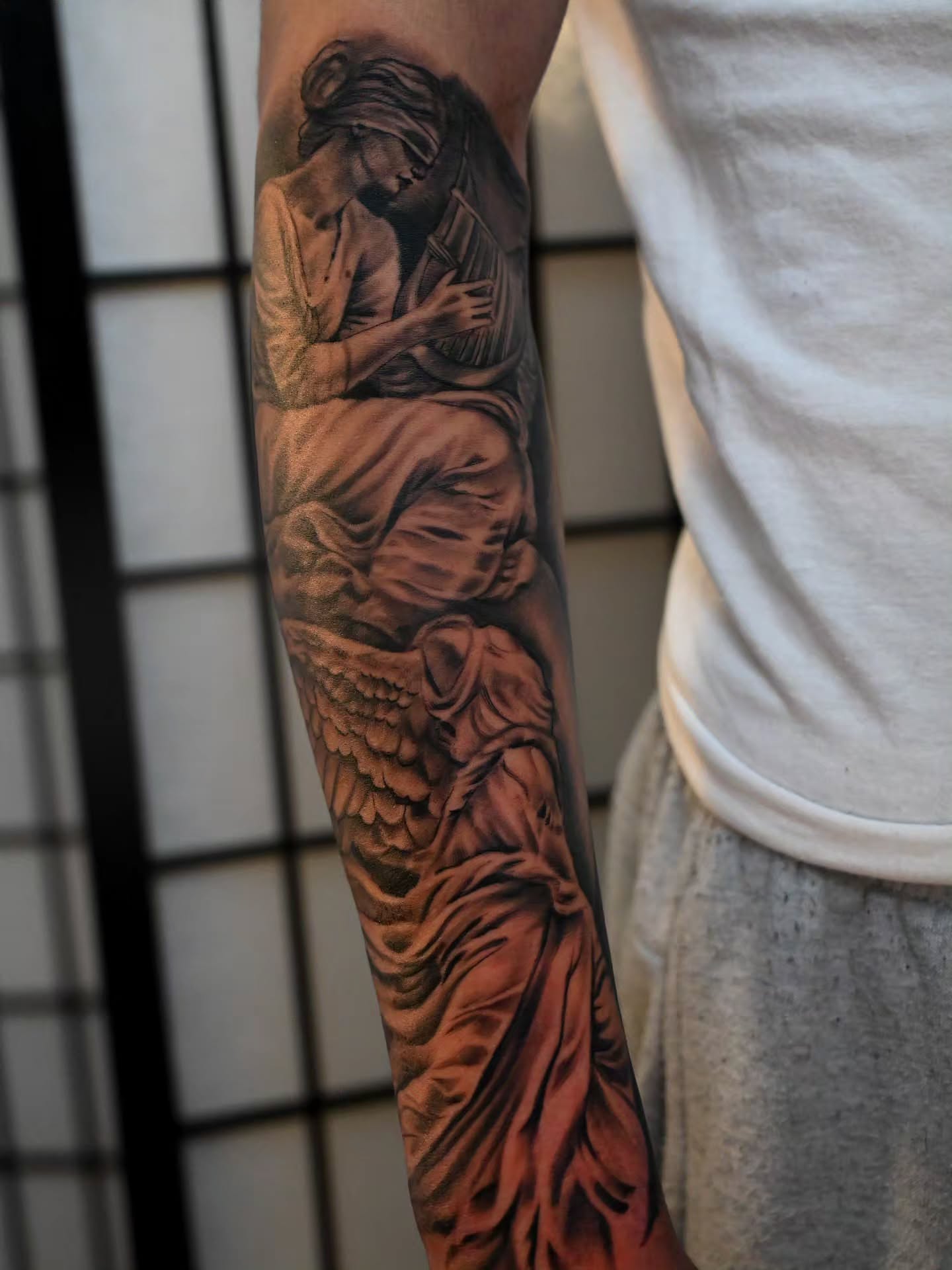 Angel reading book realism tattoo on the forearm by Michael ORegan