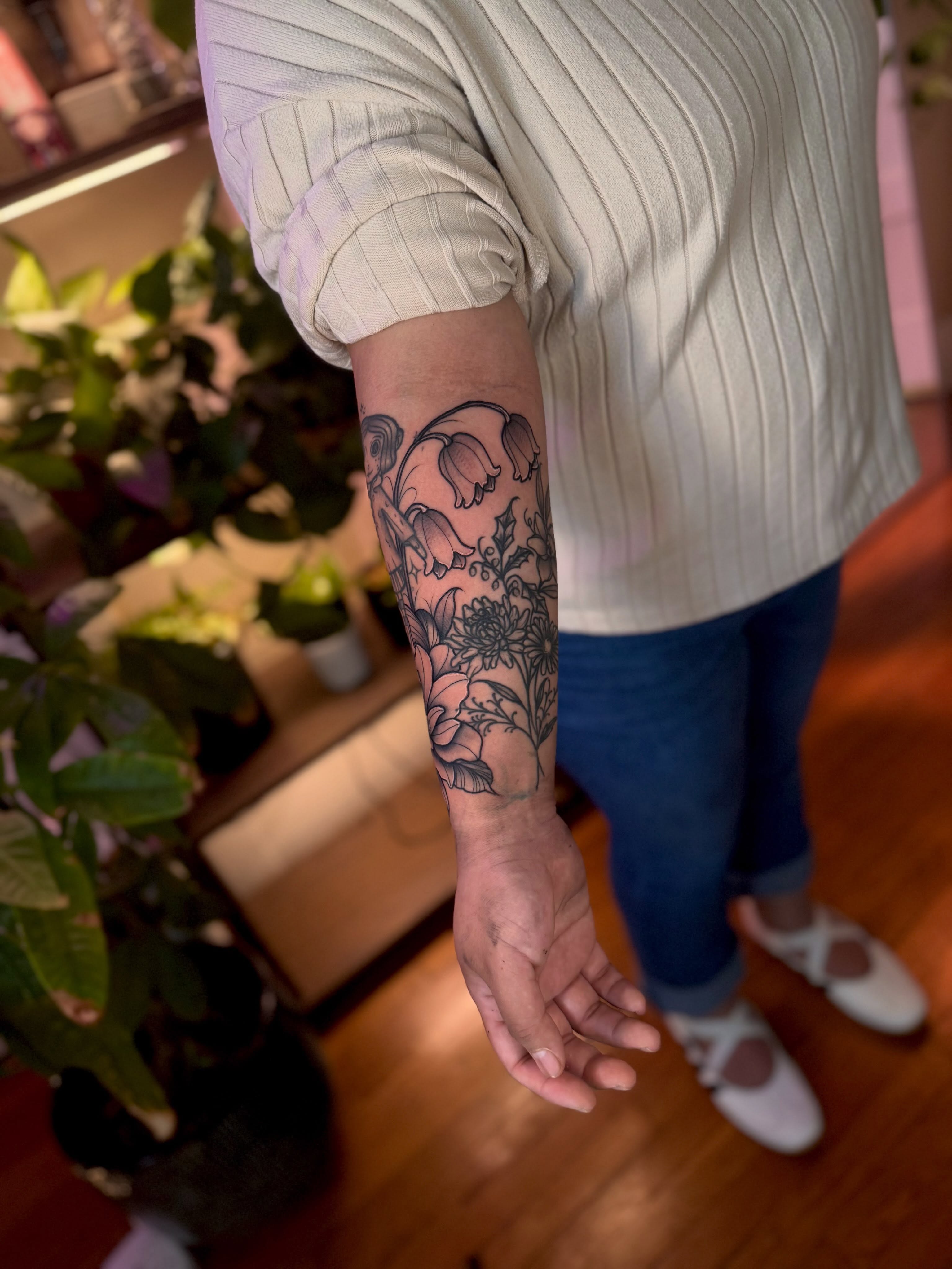 Floral bouquet black and grey tattoo on the forearm by Angie Cotton