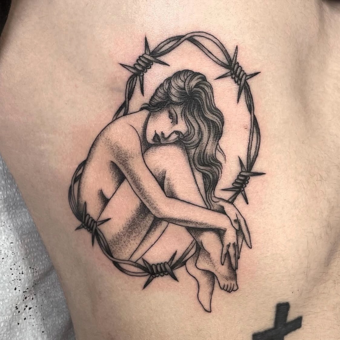 Barbed wire and woman black and grey tattoo on the thigh by Dakota Jenner