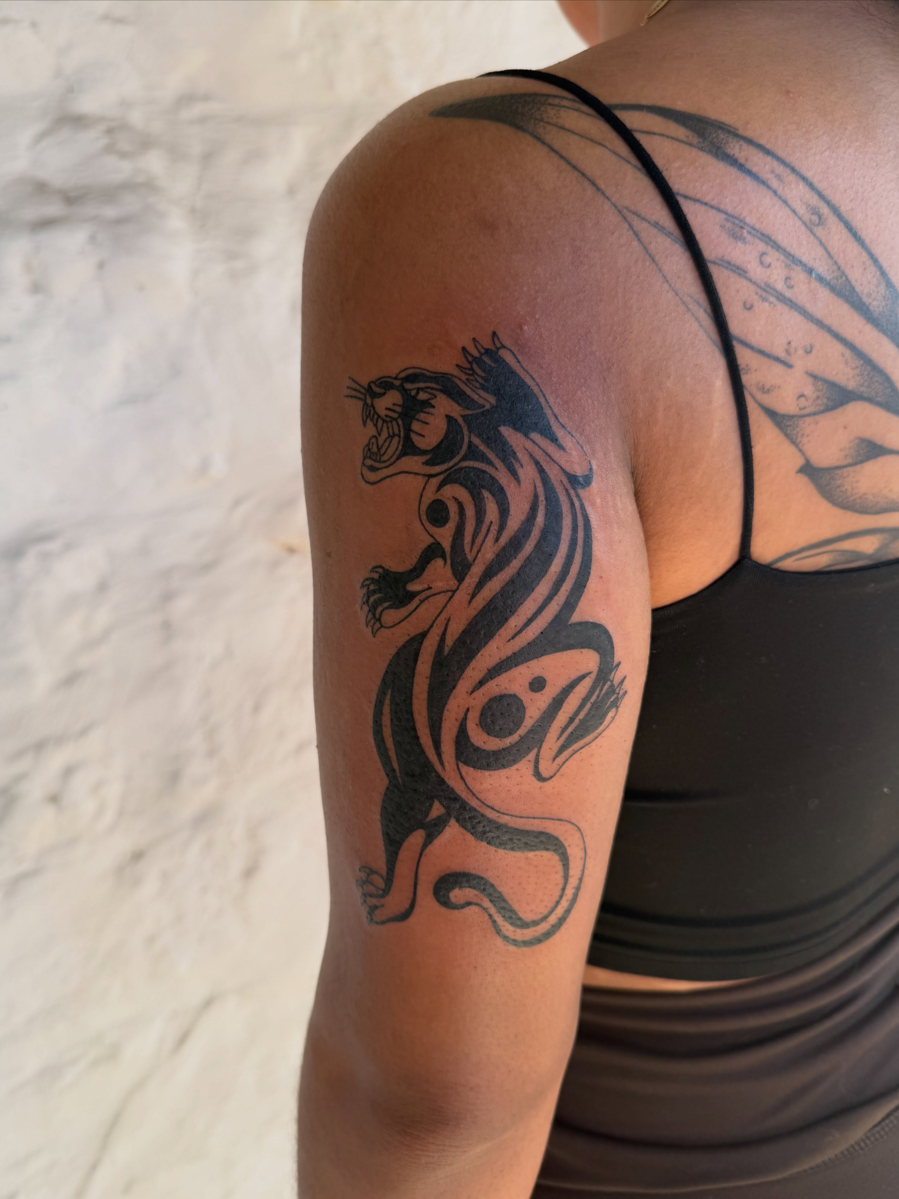 Panther tribal tattoo on the upper arm by sarah