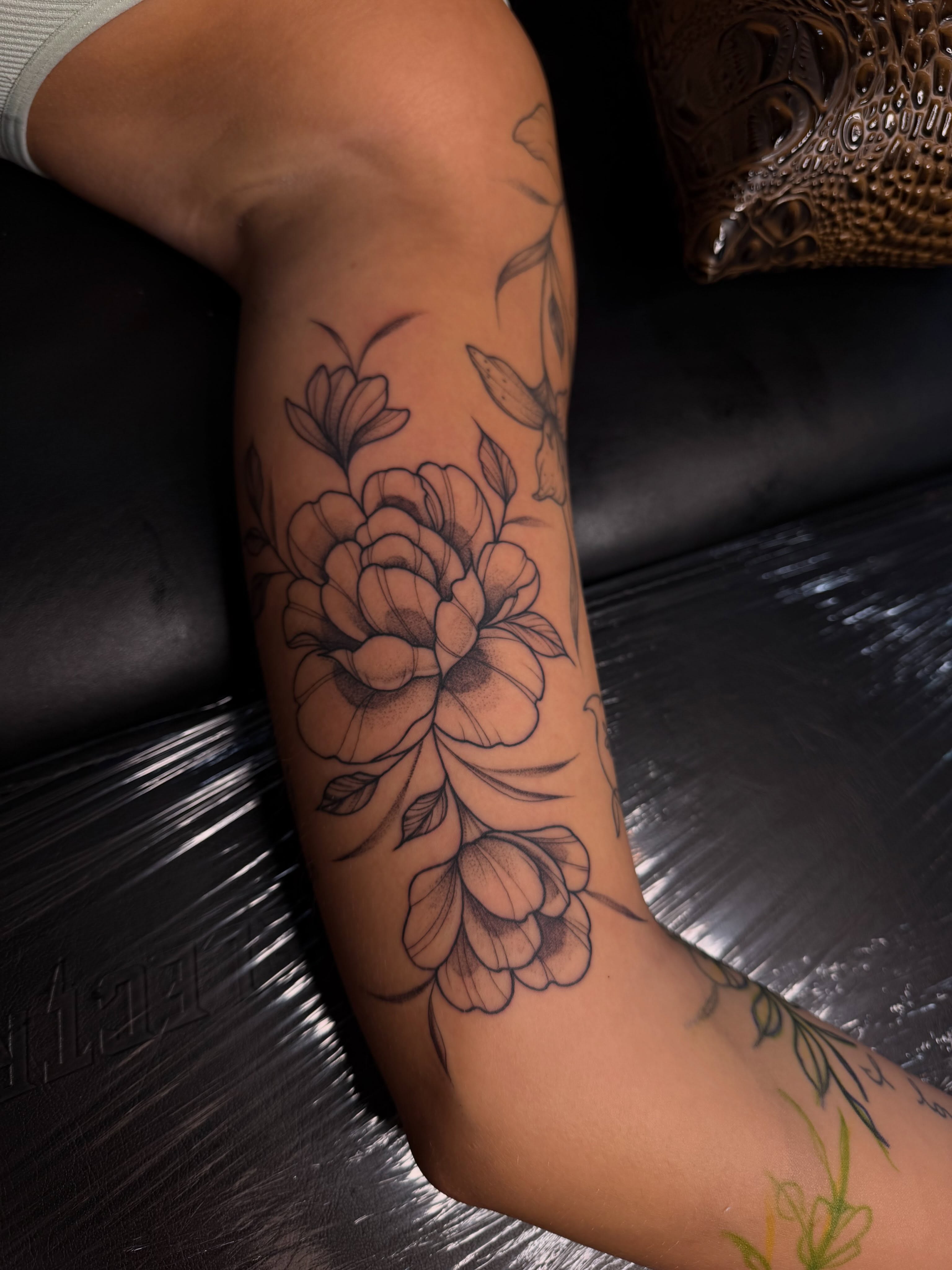 Floral bouquet black and grey tattoo on the forearm by Allison