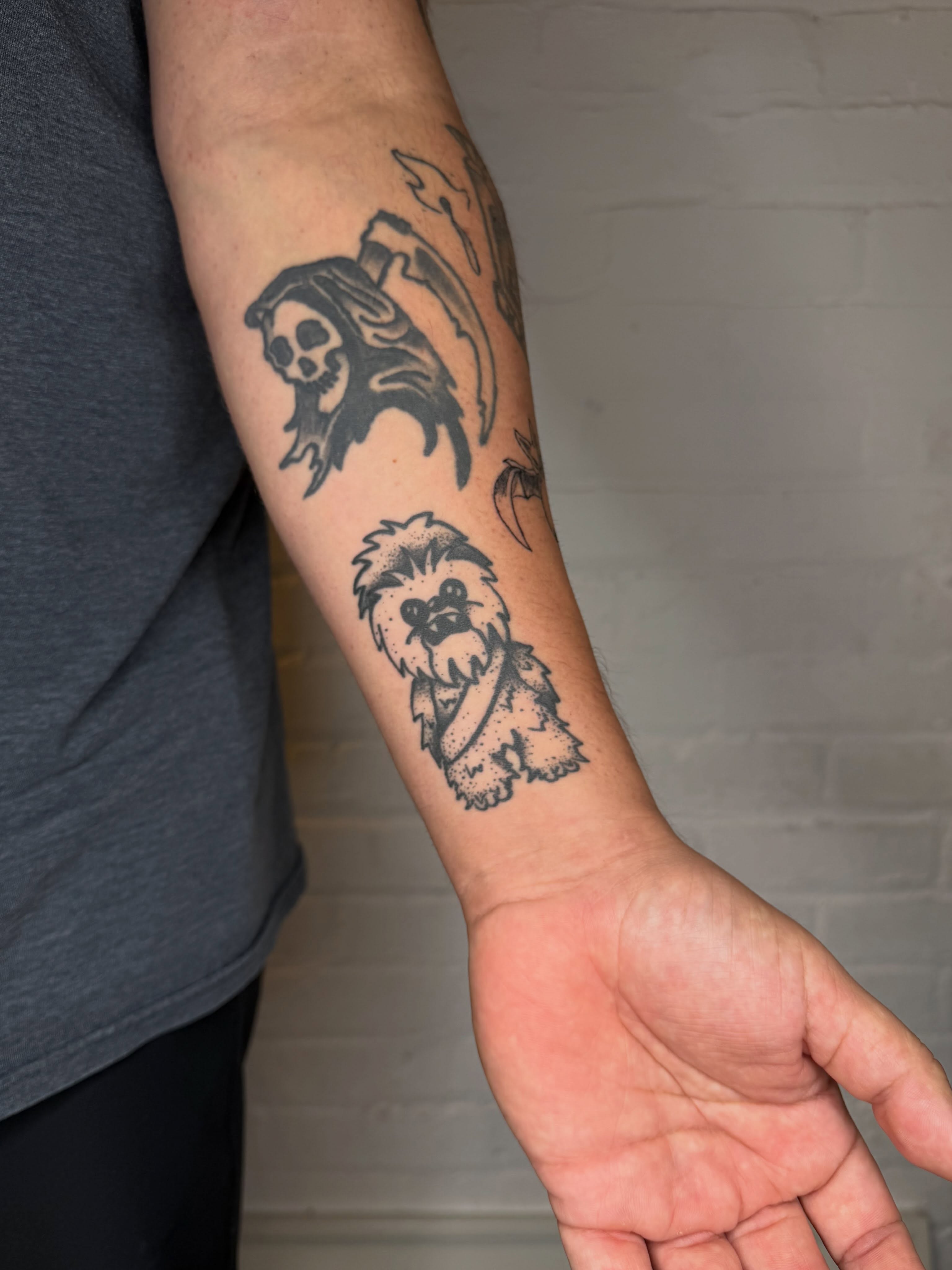 Skull and dog black and grey tattoo on the forearm by Dennis Patterson