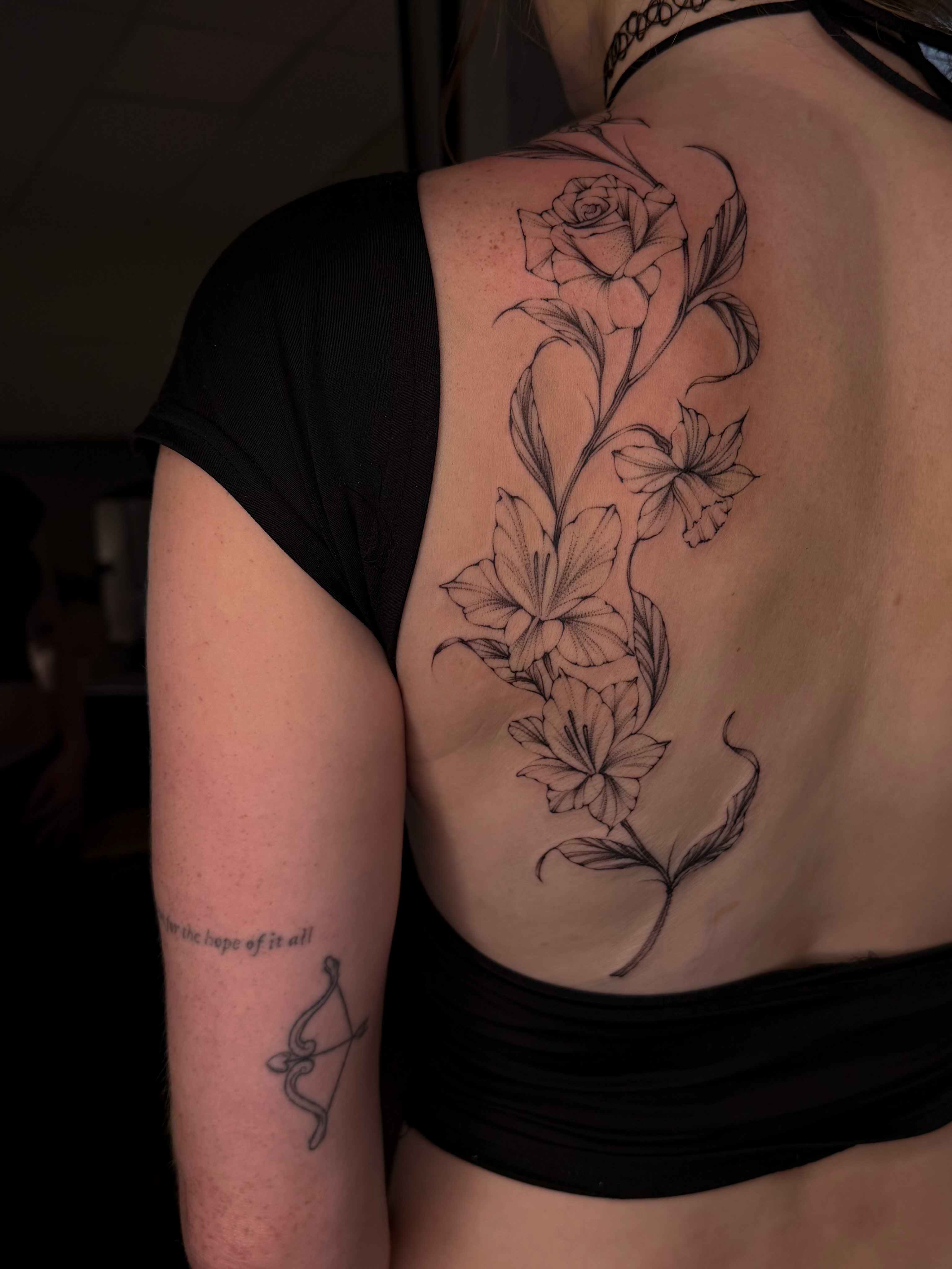 Floral vine realism tattoo on the back by Maggie Angulo