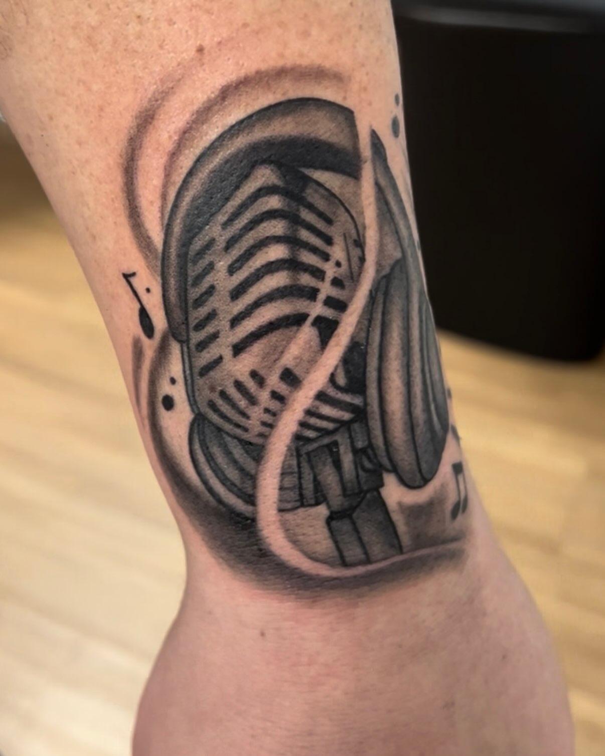Microphone black and grey tattoo on the forearm by Royal Martinez