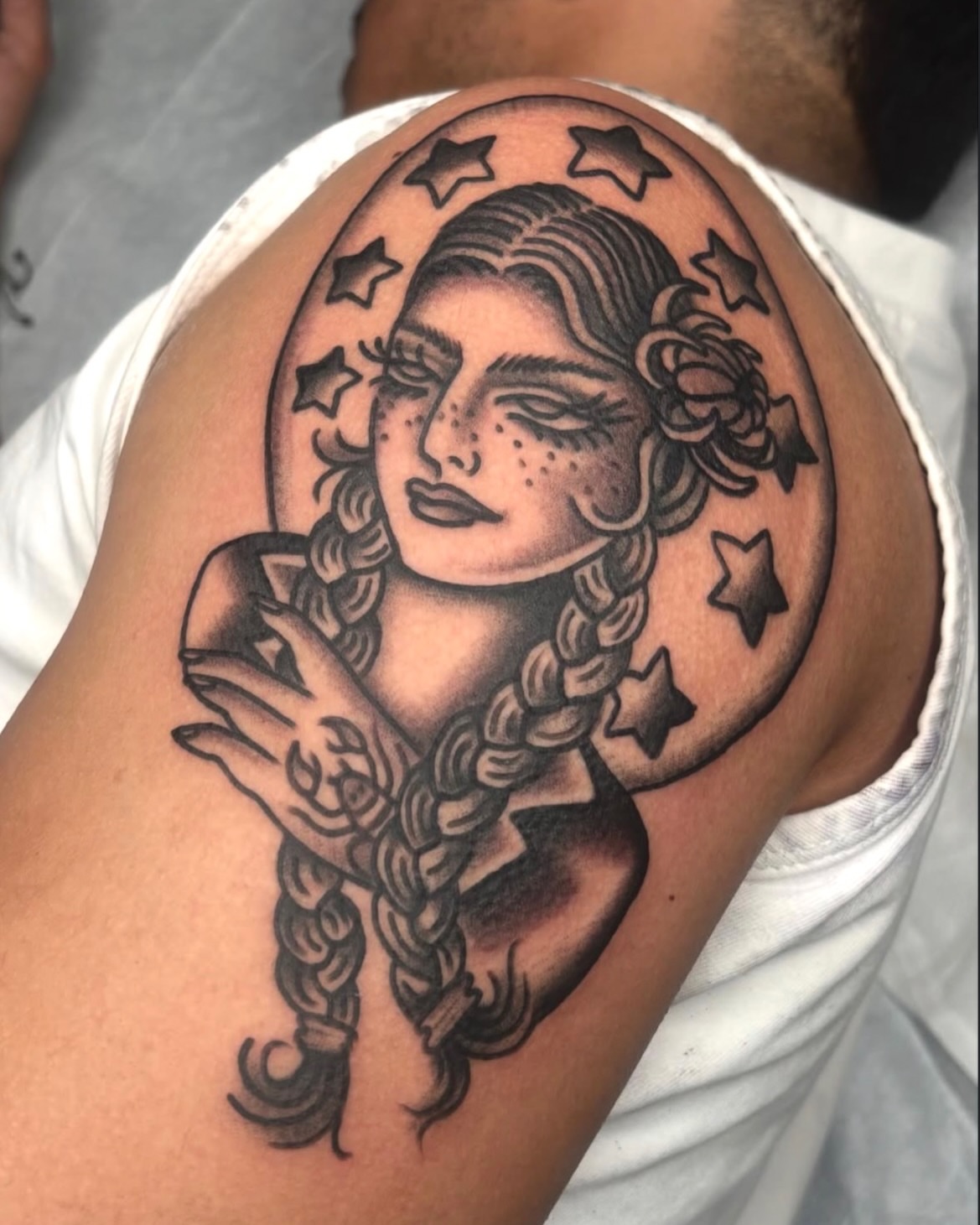 Woman with braids black and grey tattoo on the shoulder by ๐๐๐ฏ๐ข๐ซ