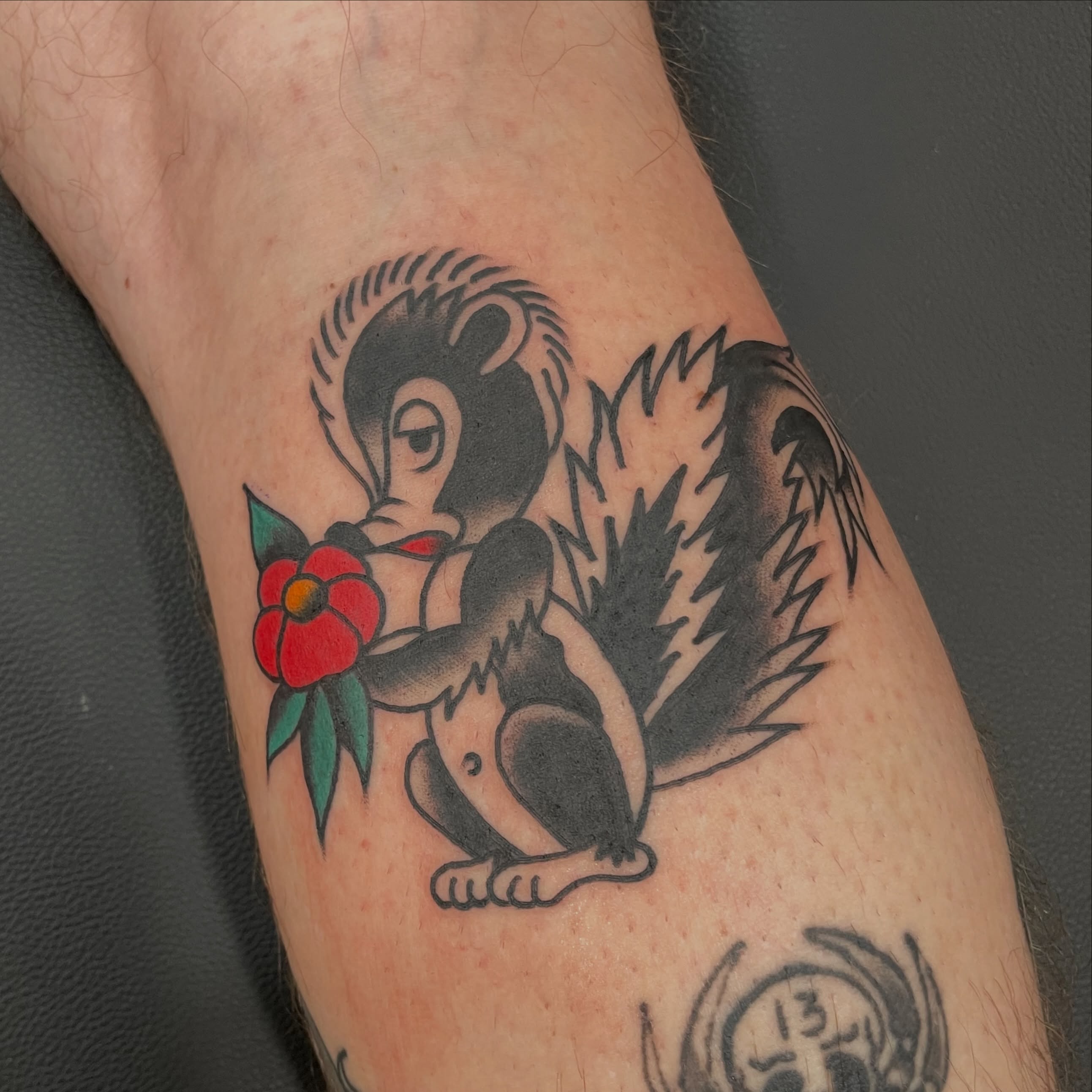 Monkey with flower American traditional tattoo on the forearm by Greg De Hoot, Youngsville, North Carolina
