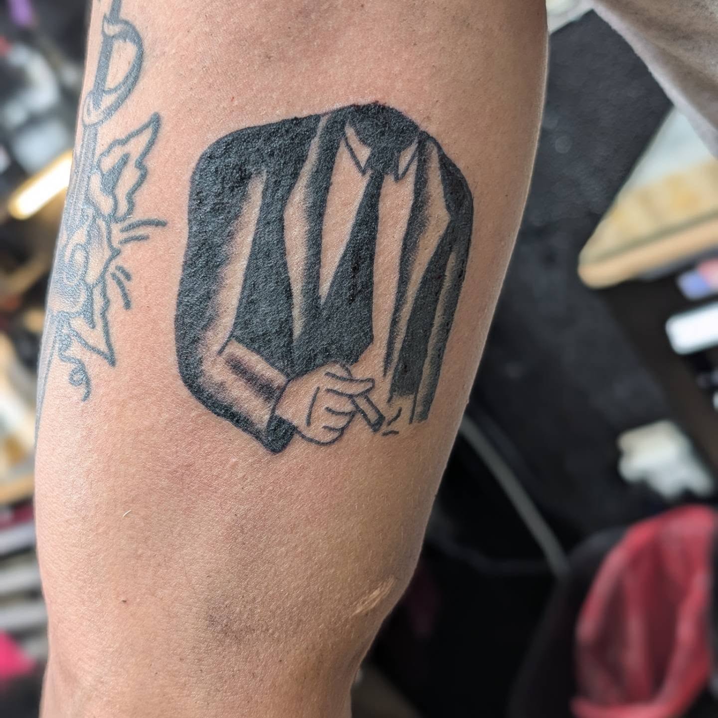 Suit and tie black and grey tattoo on the forearm by Jon Sedor