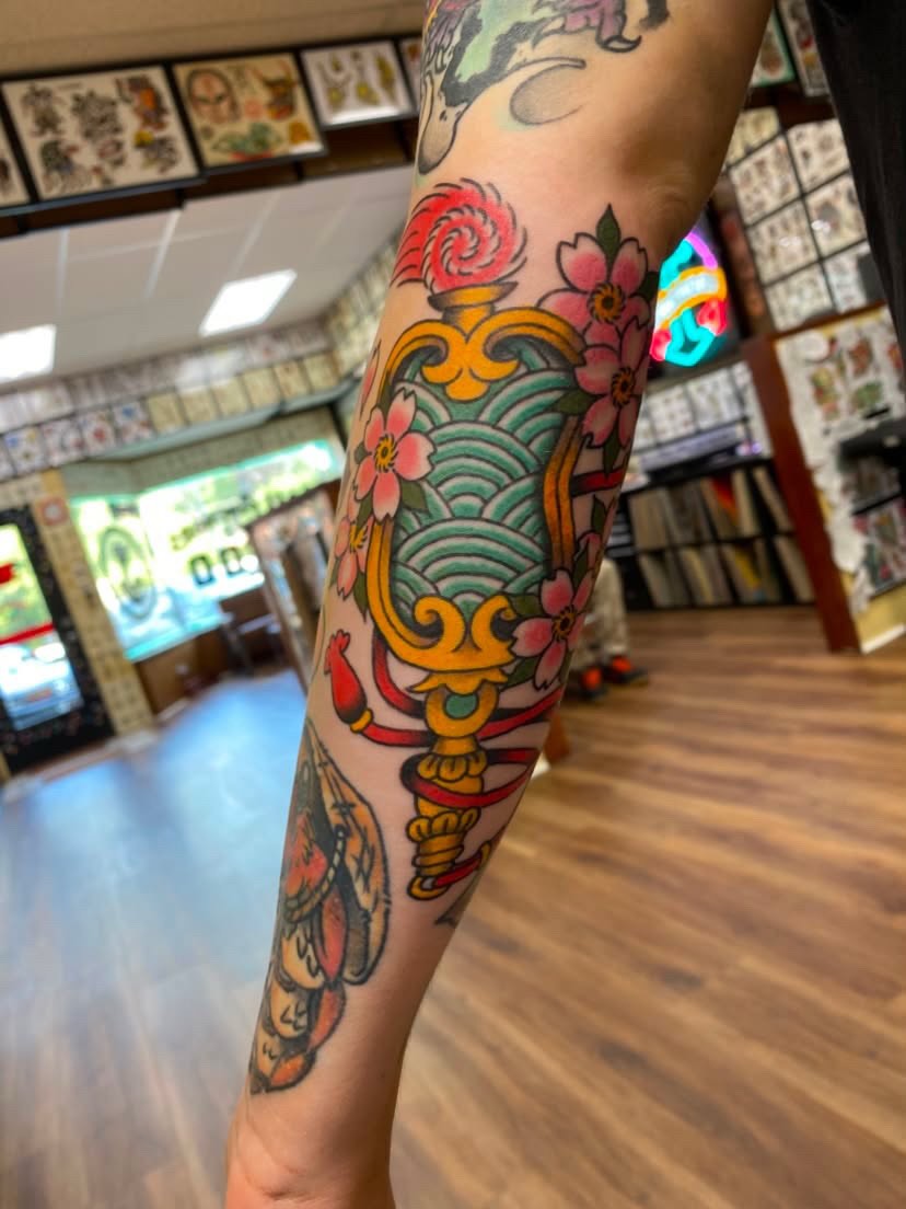 Floral arrangement with ornate vase American traditional tattoo on the forearm by Natalie Spuhler