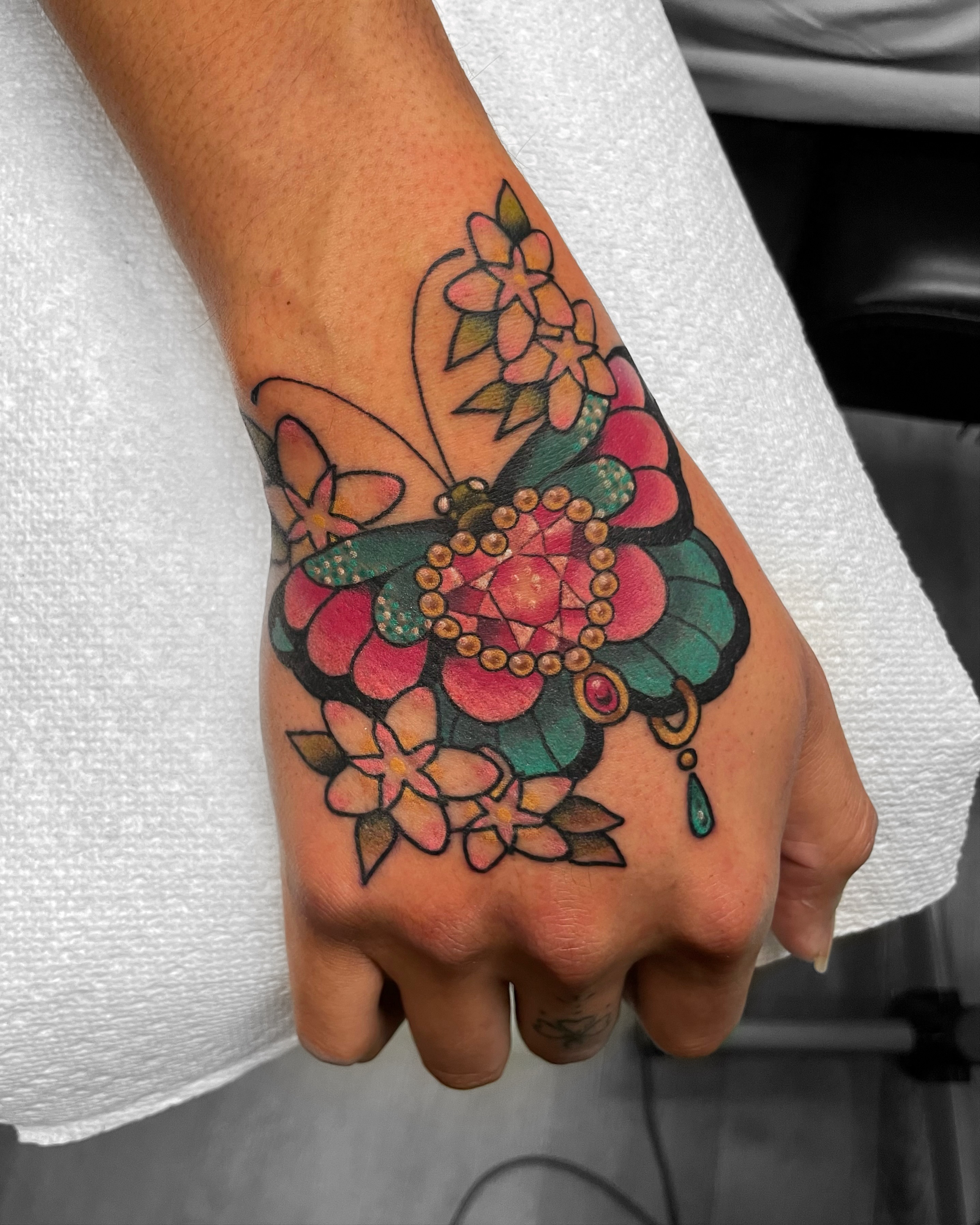 Butterfly and floral new school tattoo on the hand by 𝕬𝖓𝖆𝖇𝖊𝖑𝖑 𝕸𝖔𝖗𝖔