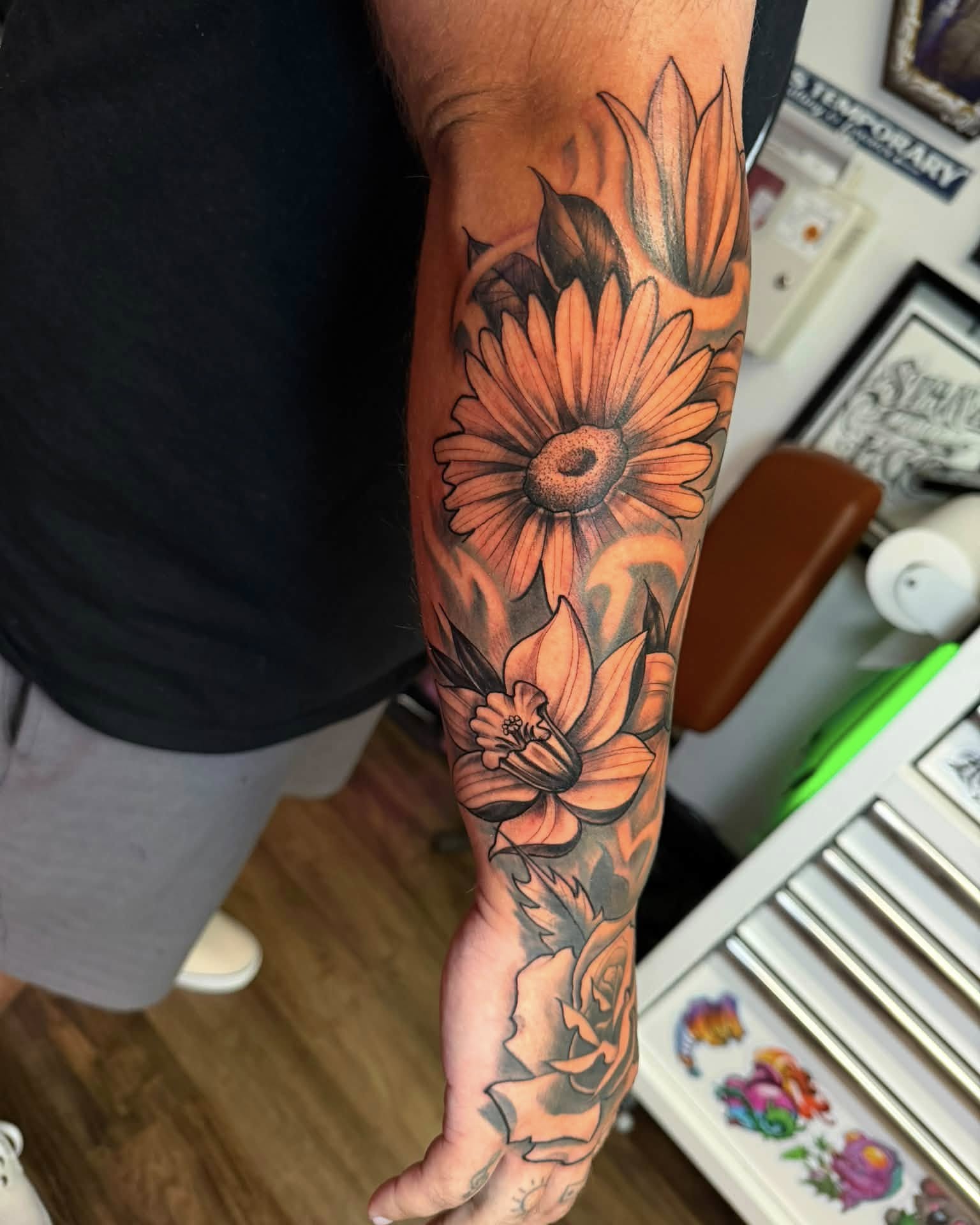 Sunflower and lotus realism tattoo on the forearm by Chad Meado