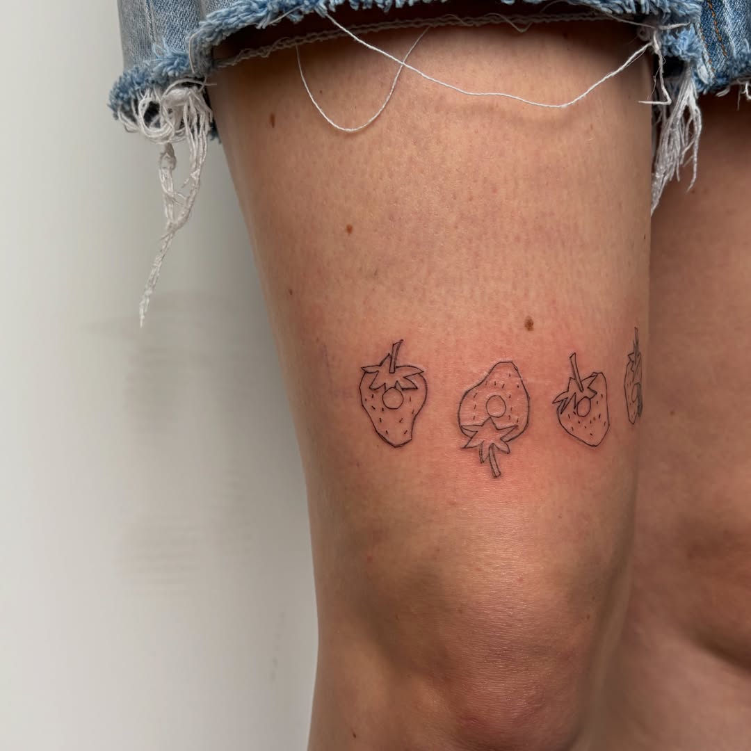 Strawberries minimalist tattoo on the thigh by annie’s tattoos ⭐꩜ .ᐟ
