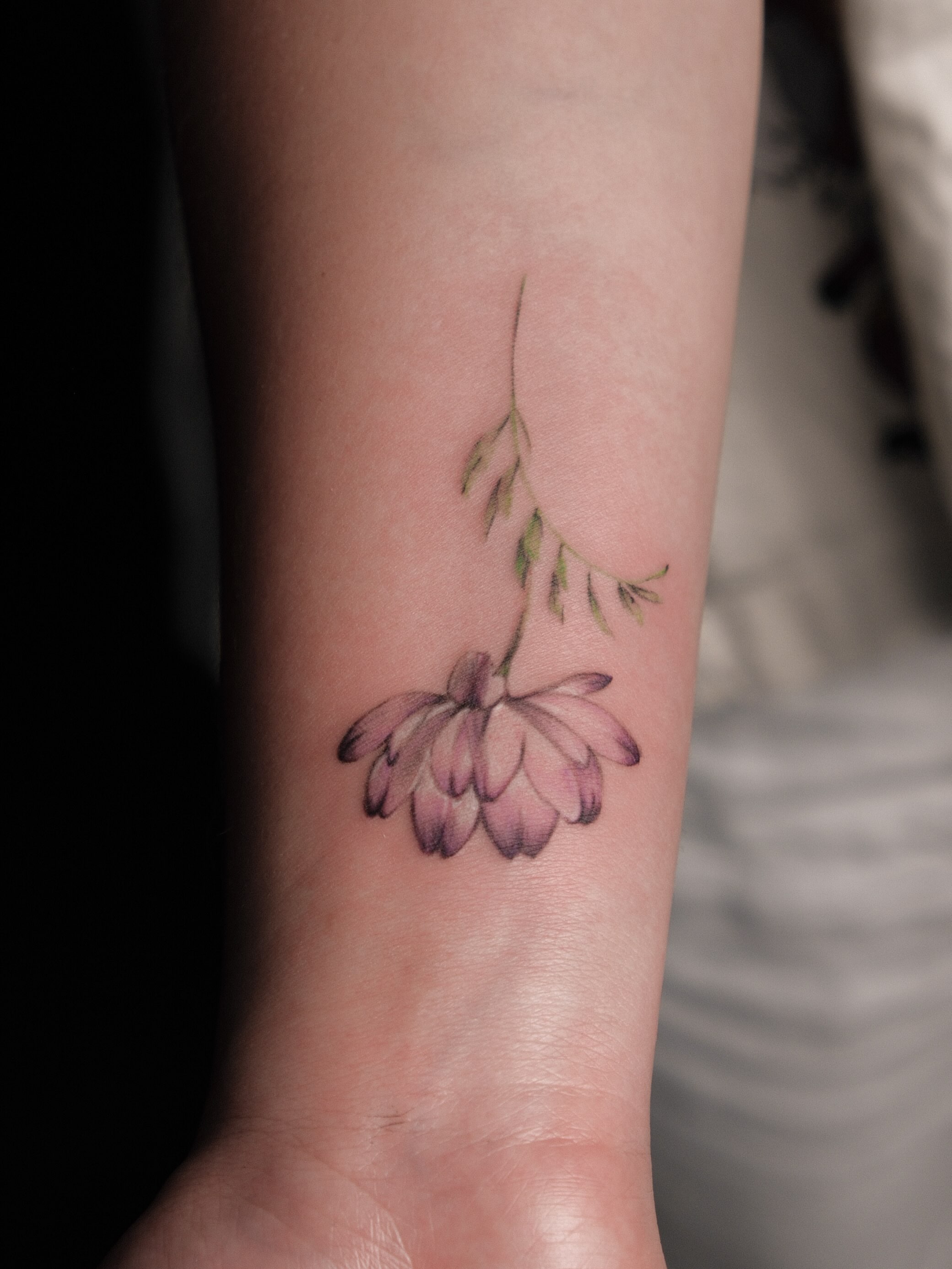 Flower cluster watercolor tattoo on the forearm by Jinz