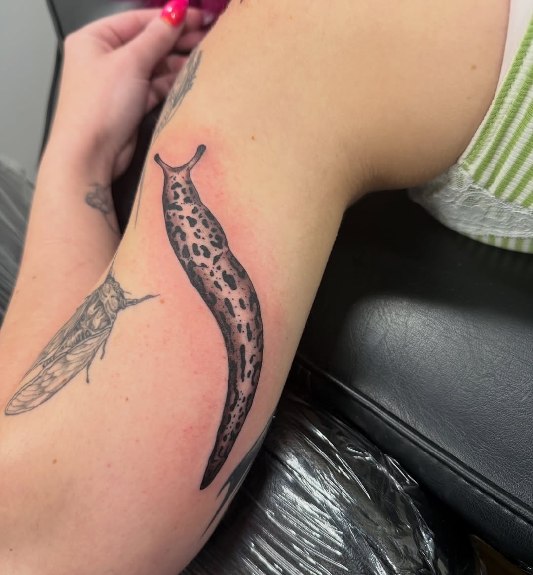 Slug black and grey tattoo on the forearm by William “Shamrock” Sammon