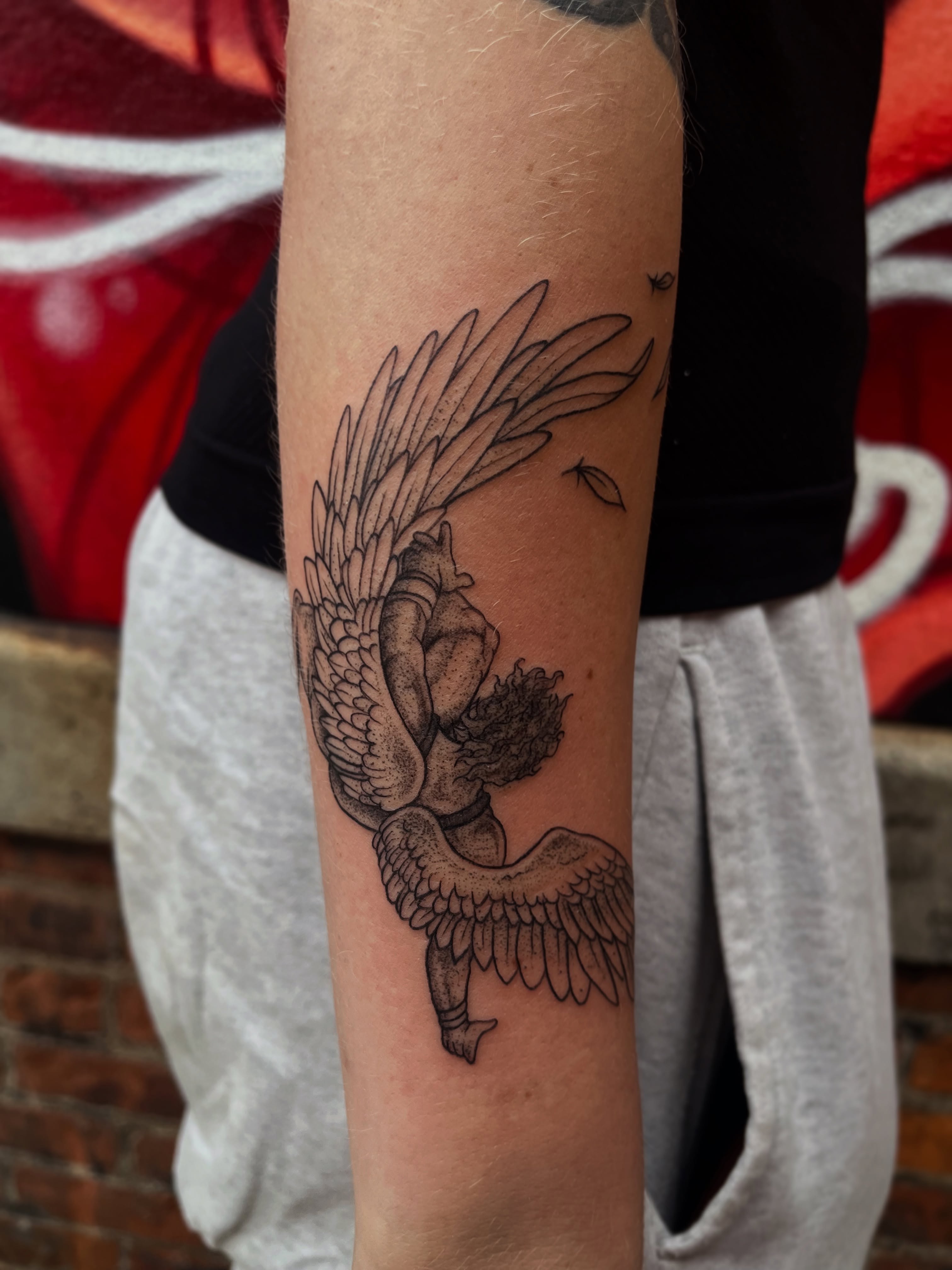 Winged angel black and grey tattoo on the forearm by Elle Miller