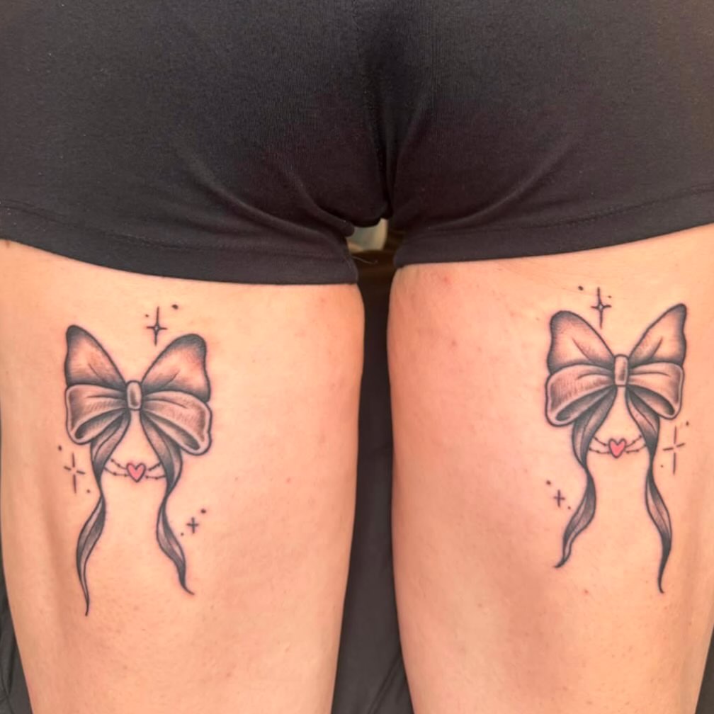 Bow black and grey tattoo on the thigh by Danielle Lorandeau