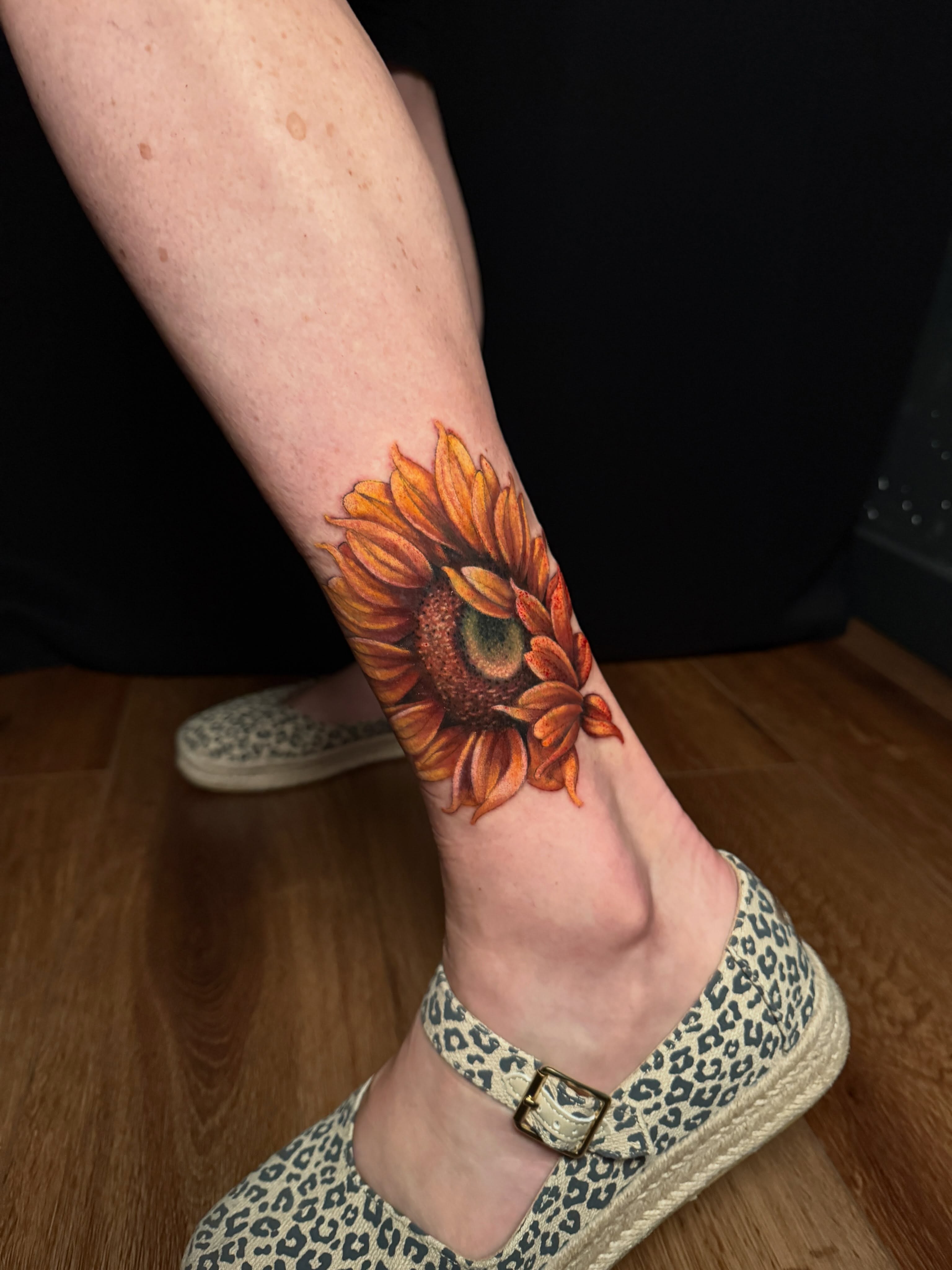 Sunflower realism tattoo on the calf by Brad Snow