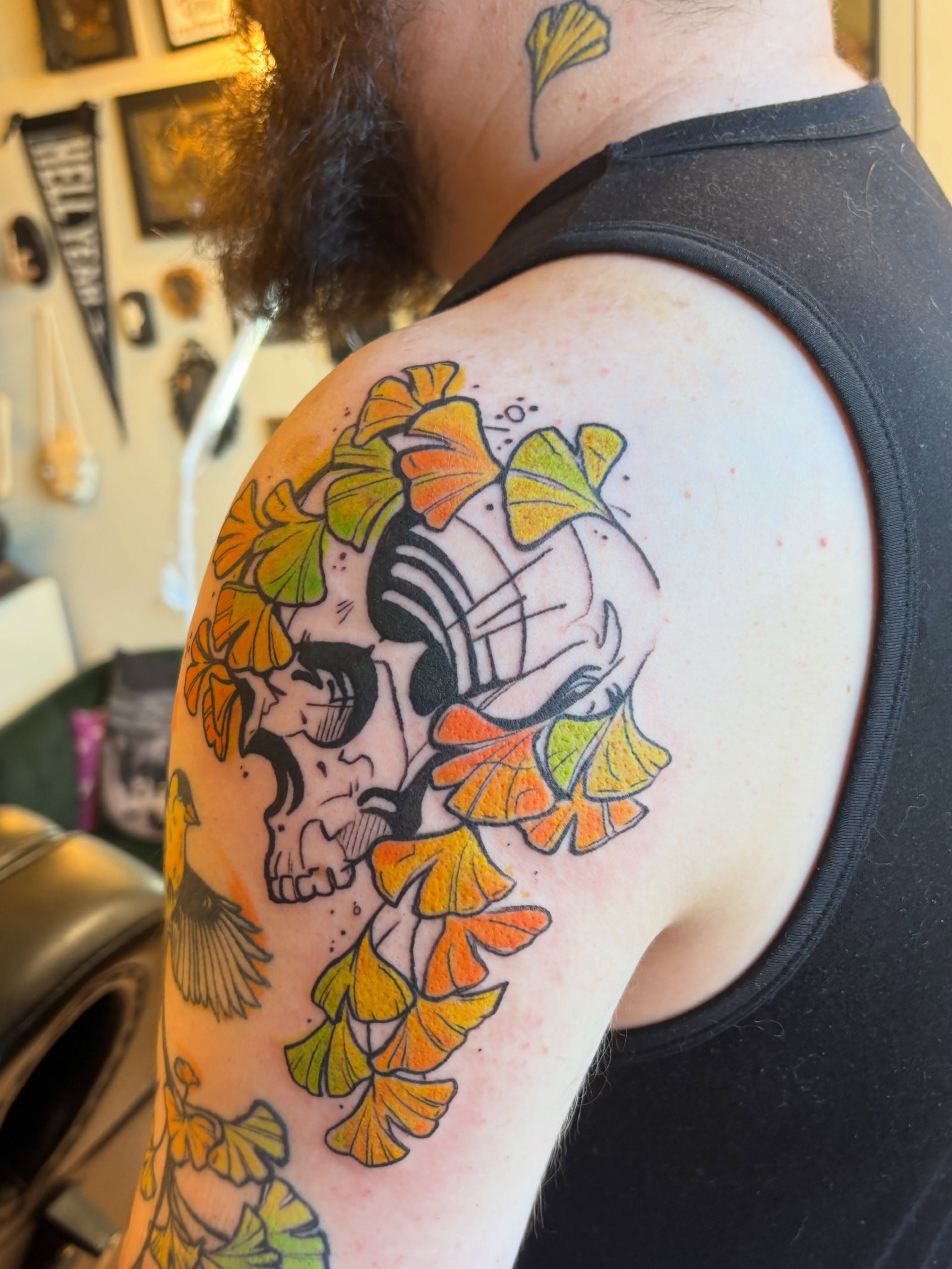 Skull with ginkgo leaves watercolor tattoo on the shoulder by Zoe Brookes