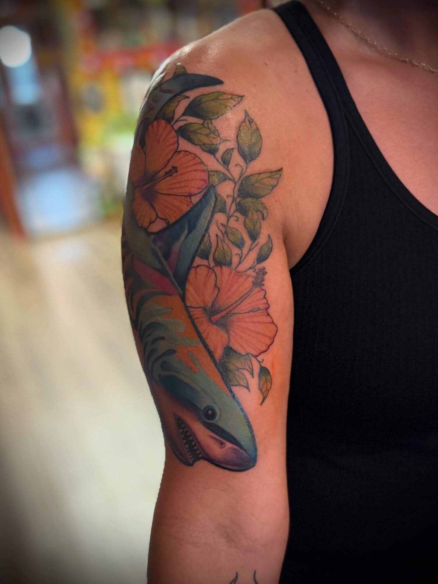 Shark and hibiscus flowers realism tattoo on the upper arm by Justin Bianchini - New Orleans Tattoo Artist