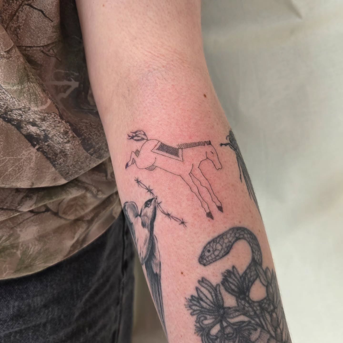 Deer and snake black and grey tattoo on the forearm by jules tattoos