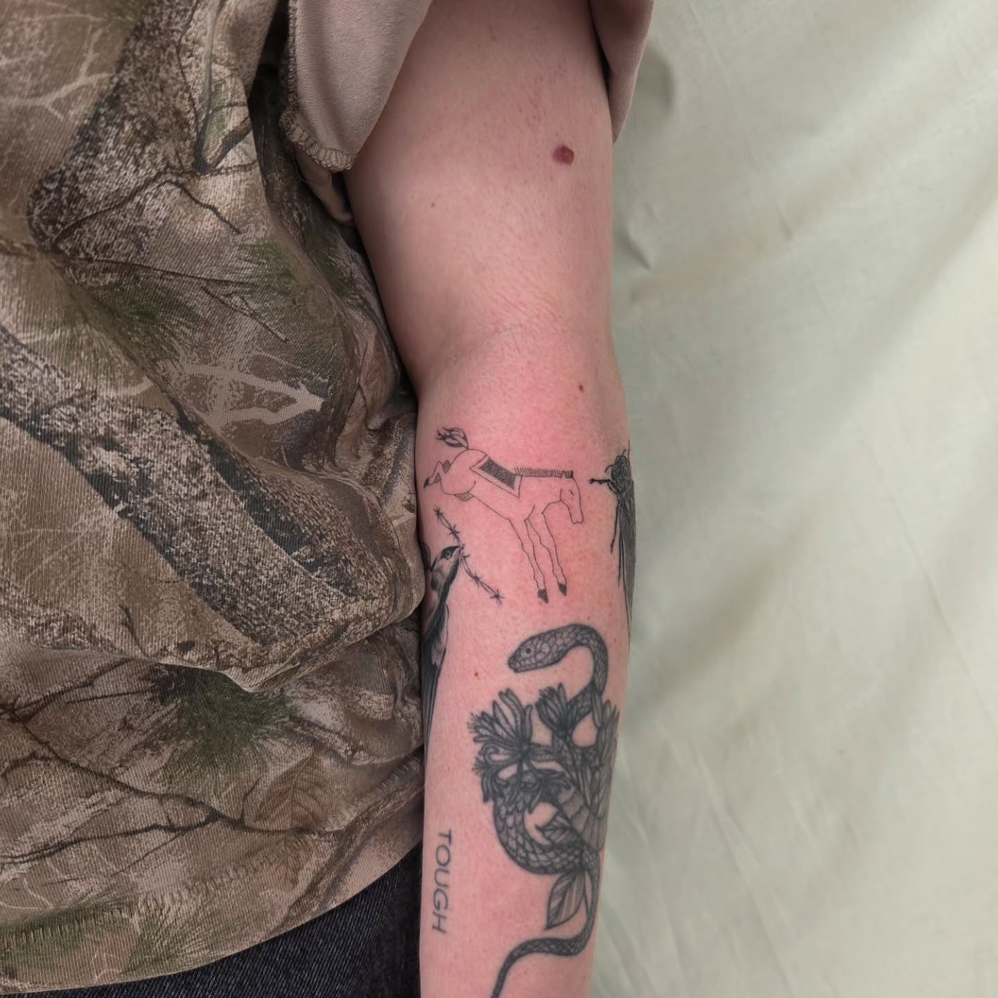 Snake and horse black and grey tattoo on the forearm by jules tattoos