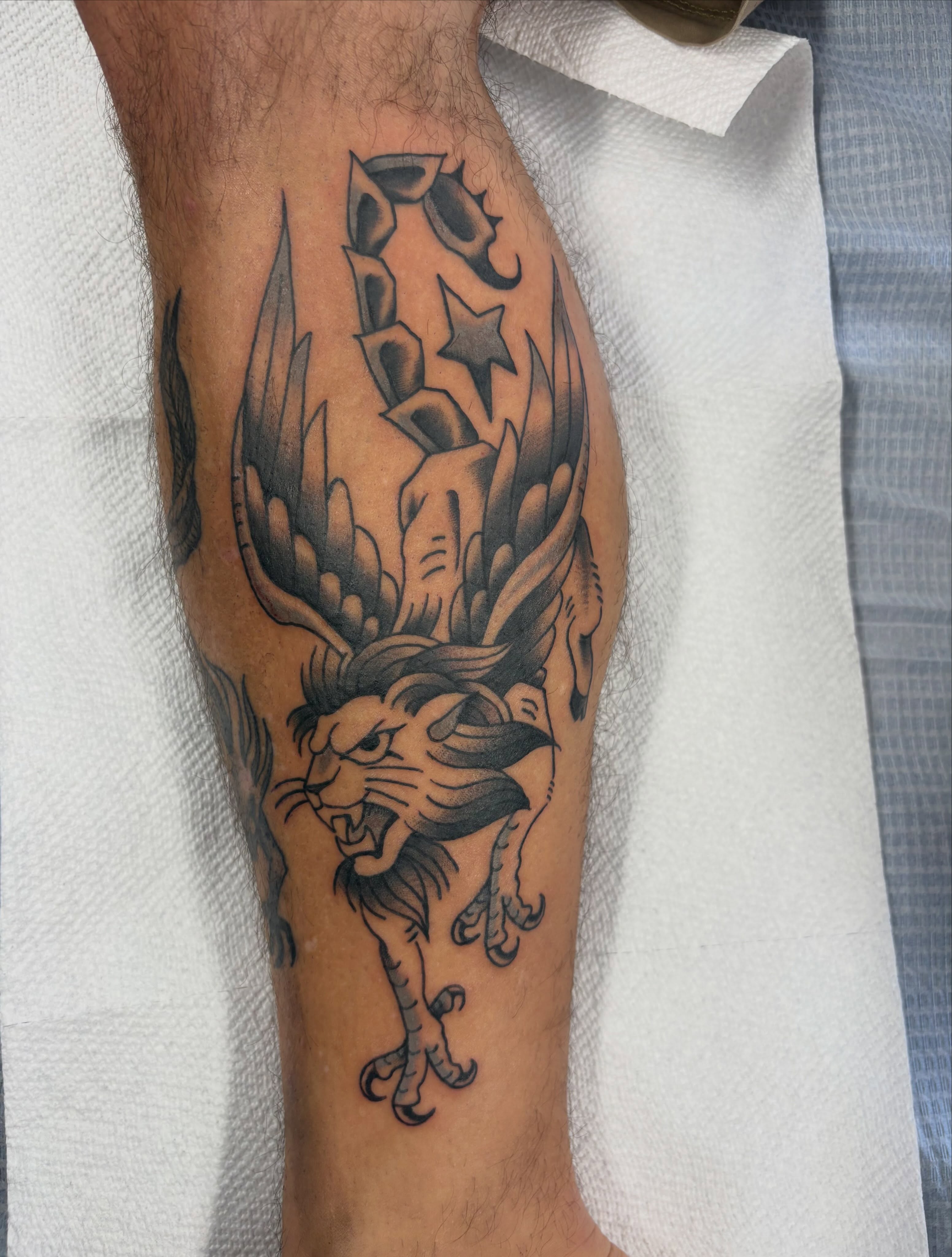 Lion and stars black and grey tattoo on the forearm by Nolan Croteau