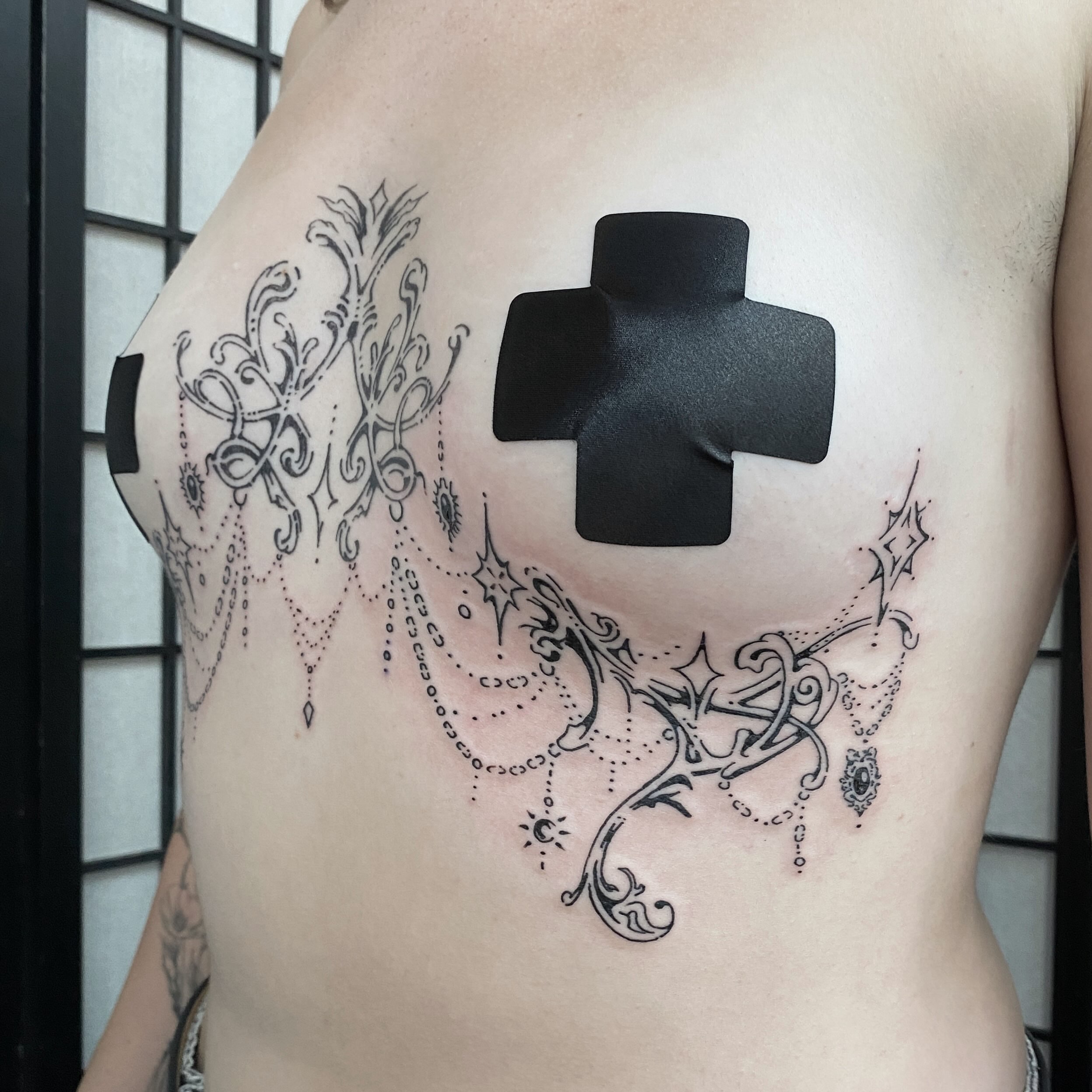 Cross with ornamental details ornamental tattoo on the chest by Clara