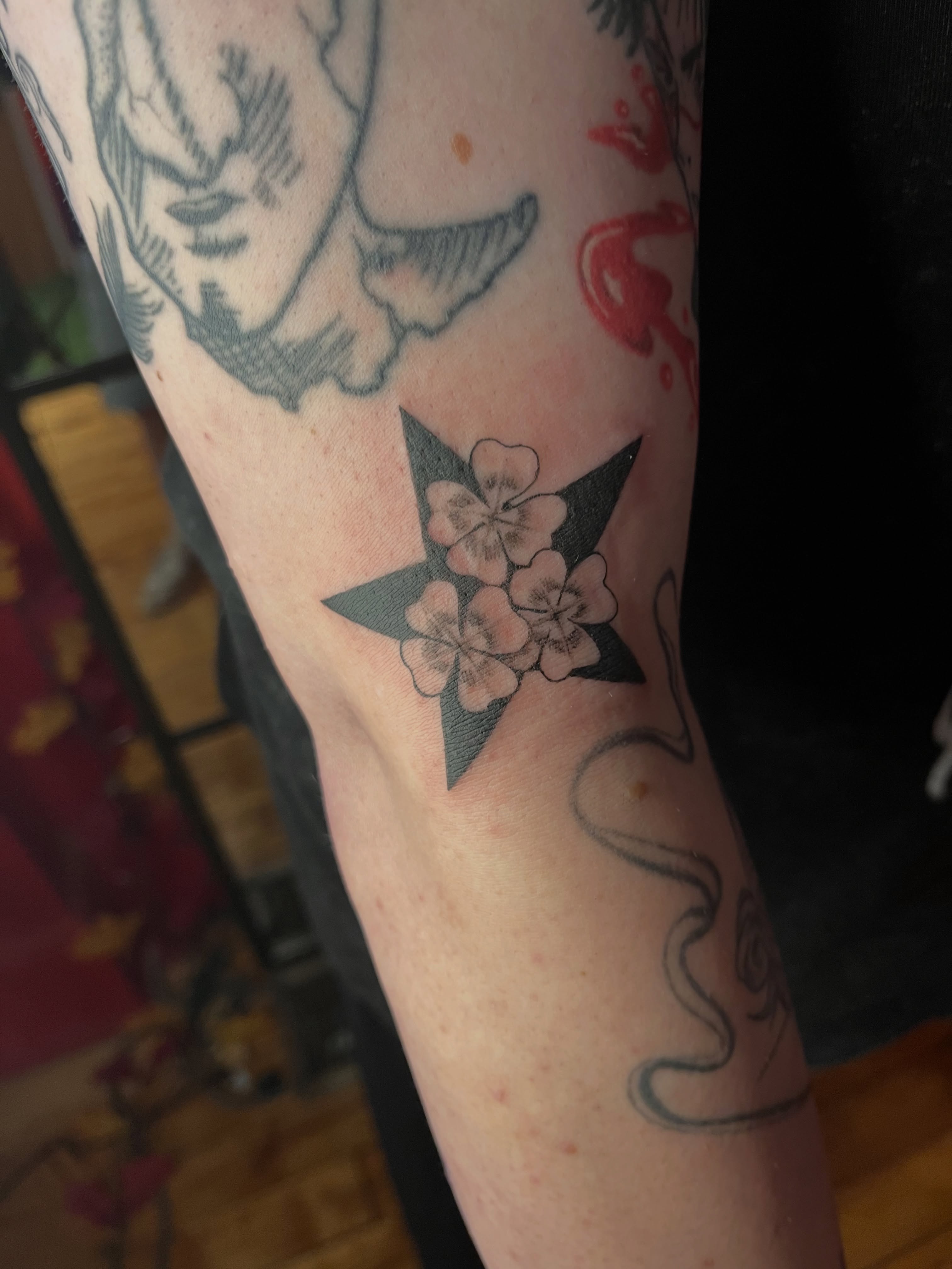 Flower star black and grey tattoo on the forearm by Zoe Phan, Richmond, Virginia