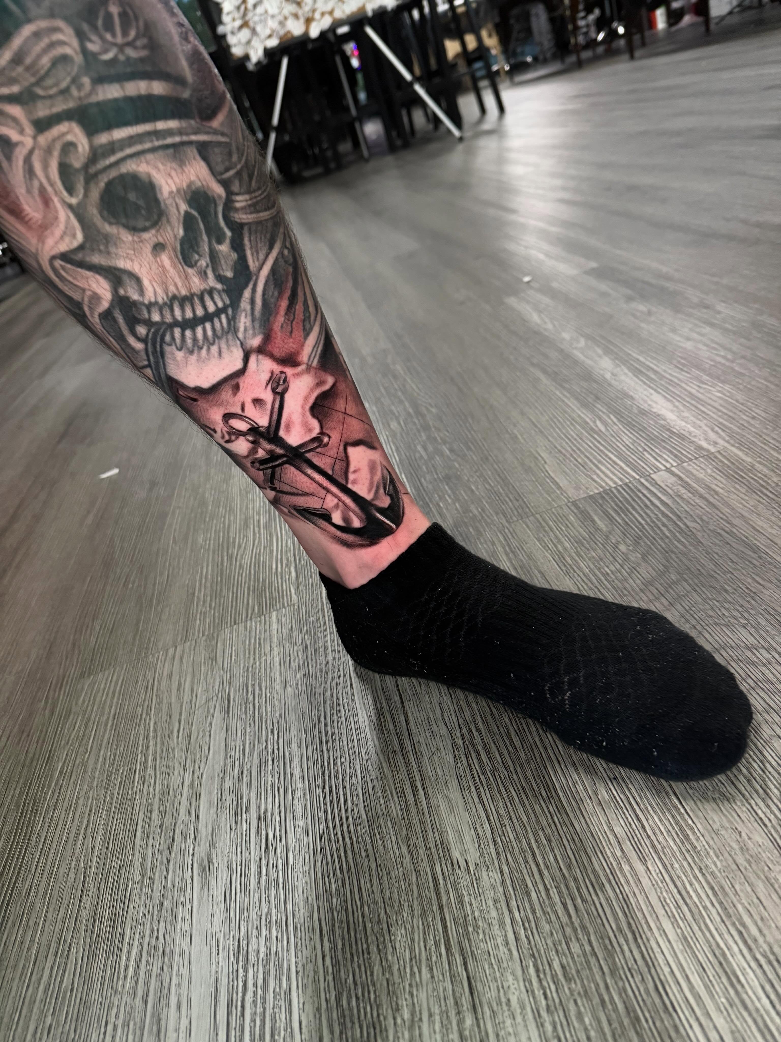 Skull and anchor American traditional tattoo on the forearm by Adrián Banuelos
