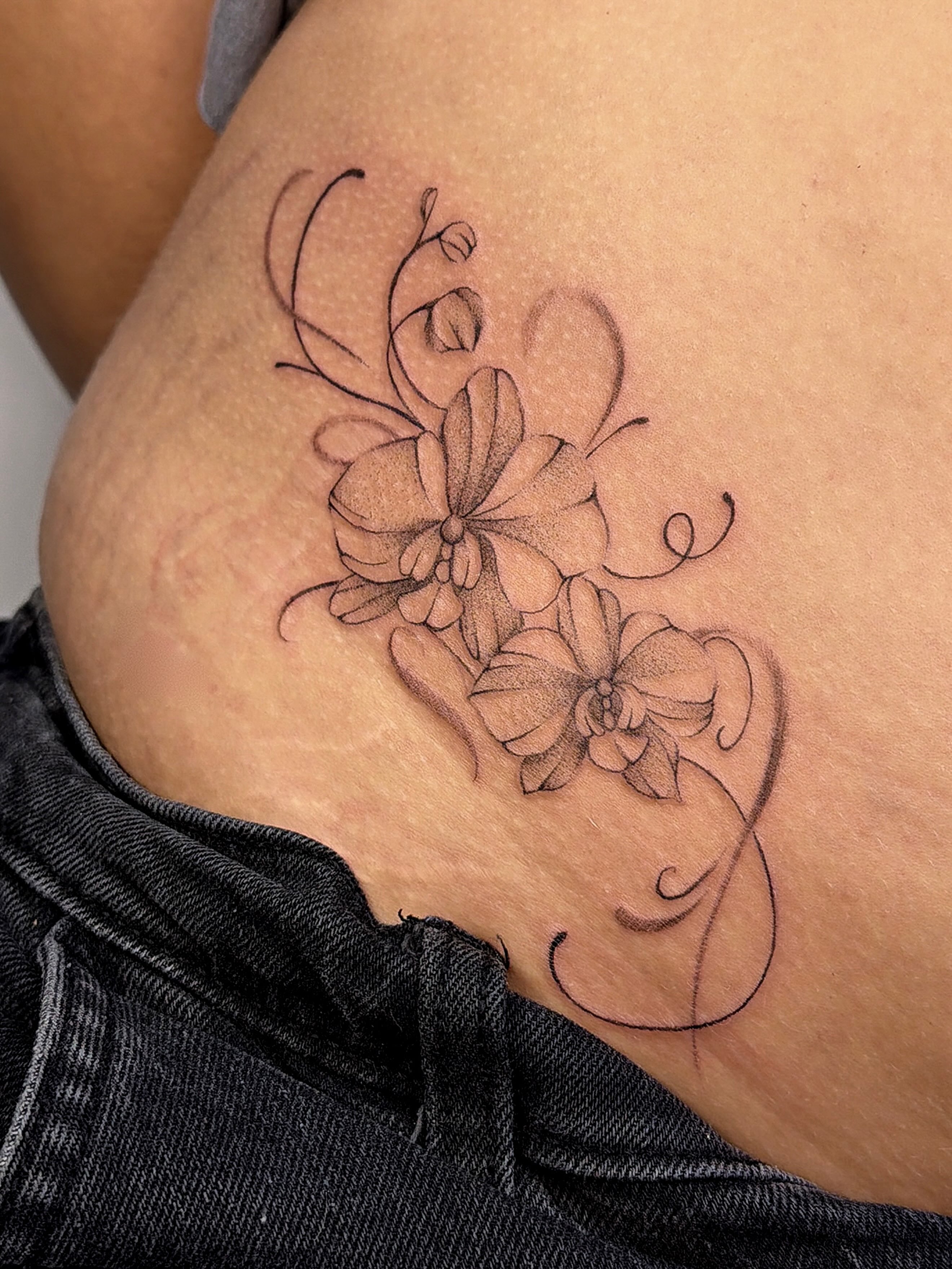 Orchids black and grey tattoo on the thigh by sarah