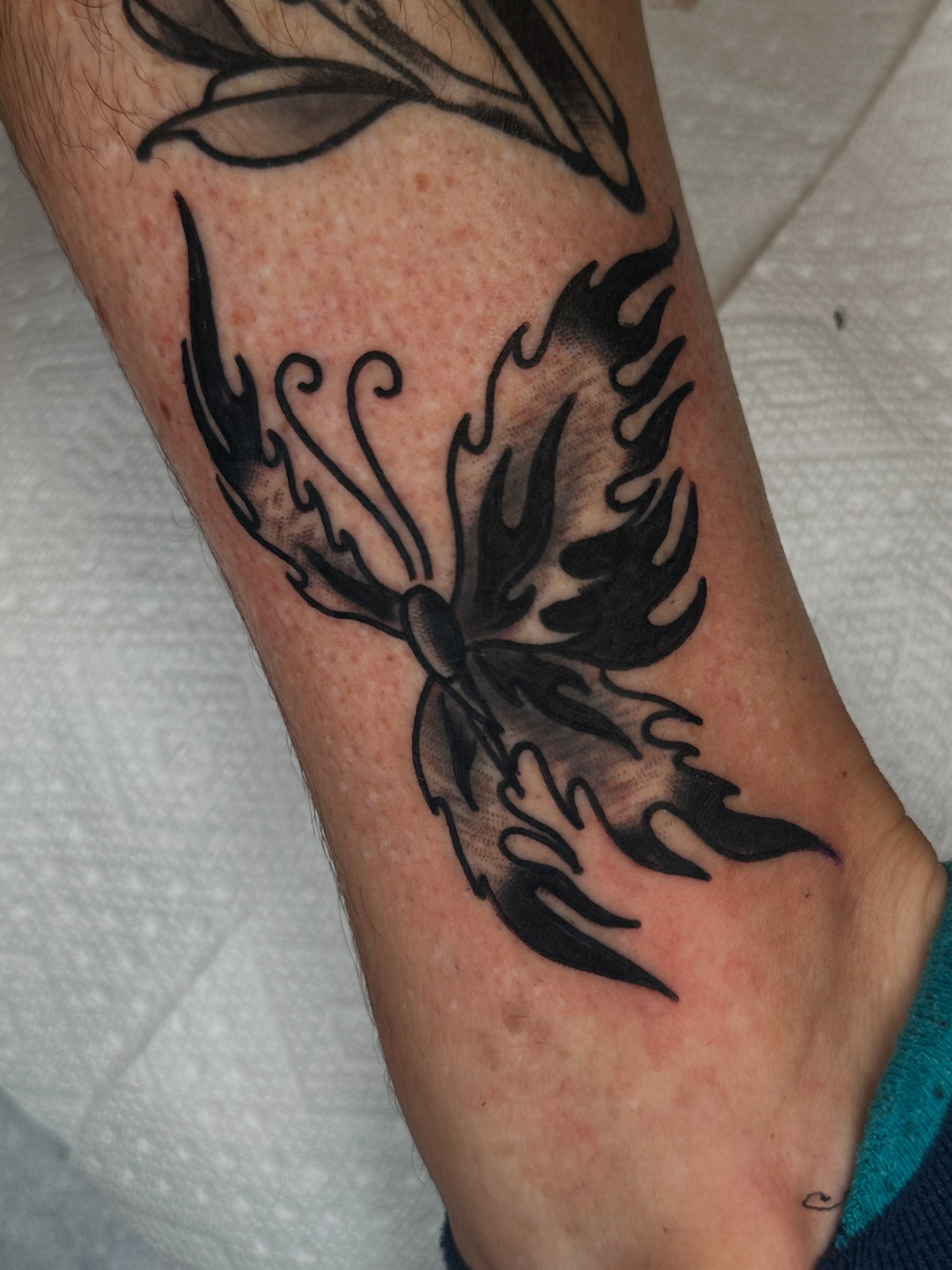 Flame black and grey tattoo on the forearm by Spencer Crawford, Speedway, Indiana